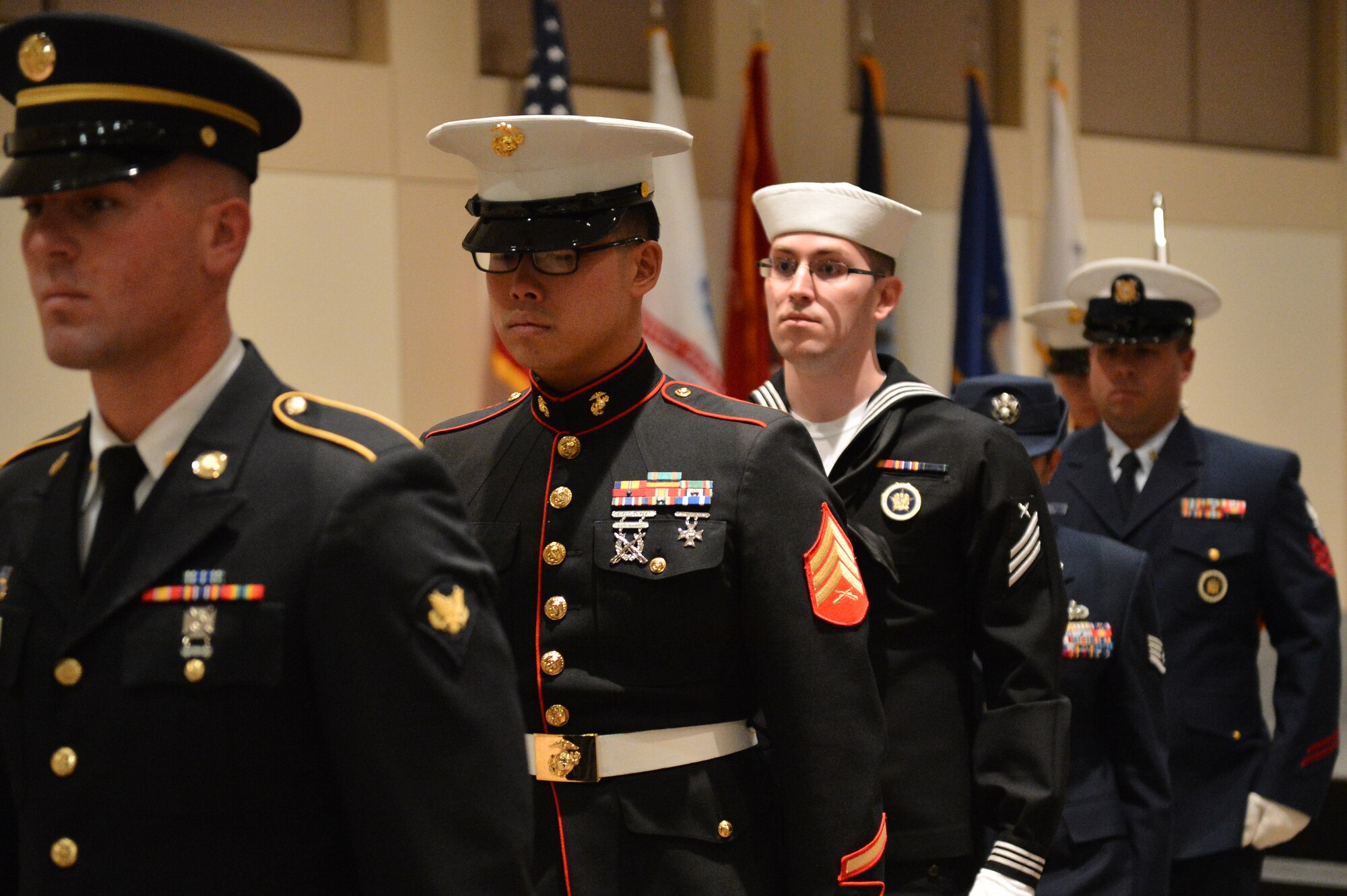 Members of the Aerospace Data Facility-Colorado Joint Color Guard exit the stage after posting colors during the Veterans Day ceremony at the Leadership Development Center Nov. 13, 2015, on Buckley Air Force Base, Colo. The ceremony included a guest speaker and a flag-folding ceremony performed by the ADF-C joint color guard. (U.S. Air Force photo by Staff Sgt. Darren Scott/Released)