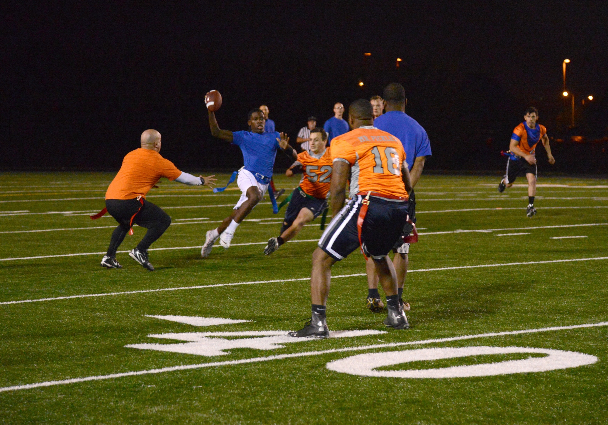Members of the 552nd Maintenance Group flag football team try to capture a flag from Zhamar Mcadory, quarterback for the Med Group. The Med Group shut out the 552MXS 21-0 in their Tuesday night matchup. Playoff games are held on Tuesday and Thursday nights starting at 5:30 p.m., with the finals being held Nov. 19. (Air Force photo by Kelly White/Released)

