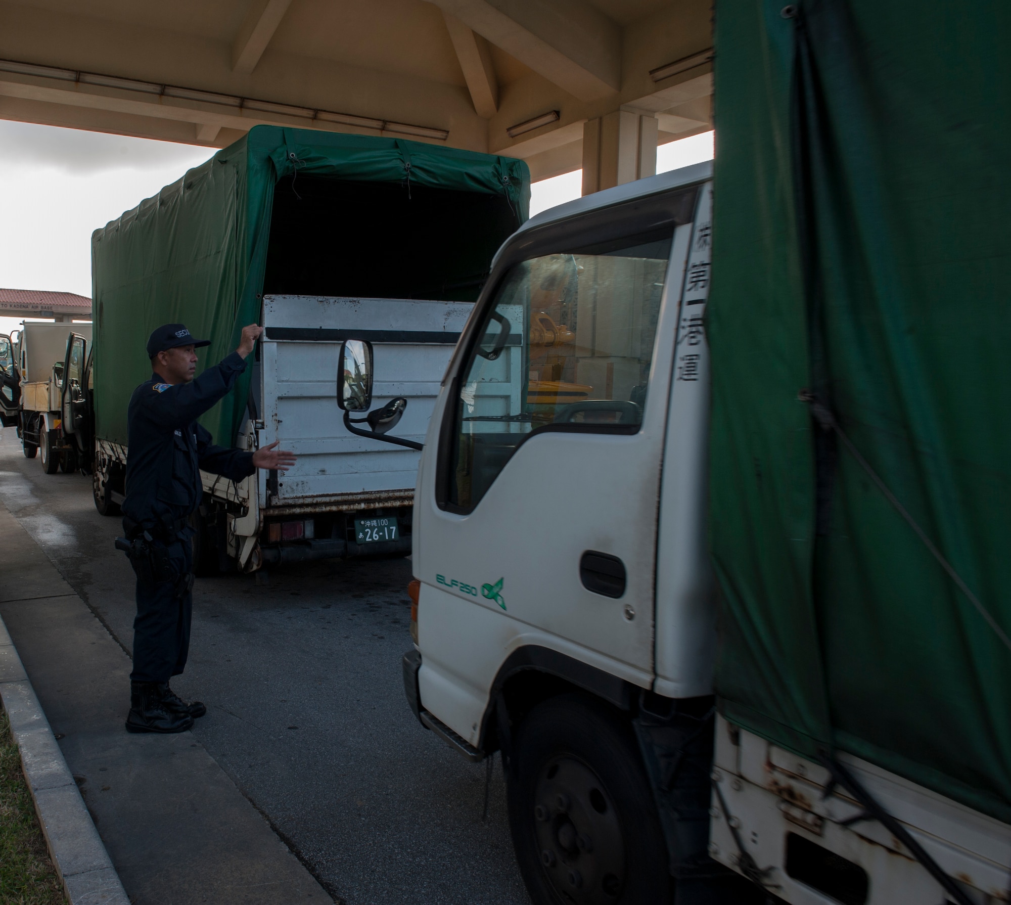 Tomohiro Nakada, 18th Security Forces Squadron member, guides a truck to the search pit Nov. 10, 2015, at Kadena Air Base, Japan. Airmen from the Air Force Smart Operations for the 21st Century team on Kadena opened the search pit an hour earlier as a solution to process commercial trucks faster as they arrive on base. (U.S. Air Force photo by Airman 1st Class Lynette M. Rolen)