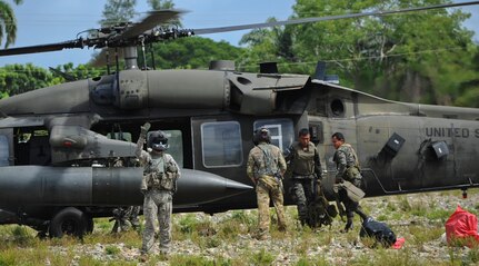 A crew chief with the 1-228th Aviation Regiment signals to Honduran soldiers preparing to disembark for a forward operating location Nov. 4, 2015, in the Gracias a Dios department (state) of Honduras. The 1-228th and members of Joint Task Force-Bravo provided airlift capabilities to the Hondurans as they rotated forces in the area to combat trans-national organized crime organizations in the Honduran borders. (U.S. Air Force photo by Capt. Christopher J. Mesnard/Released)