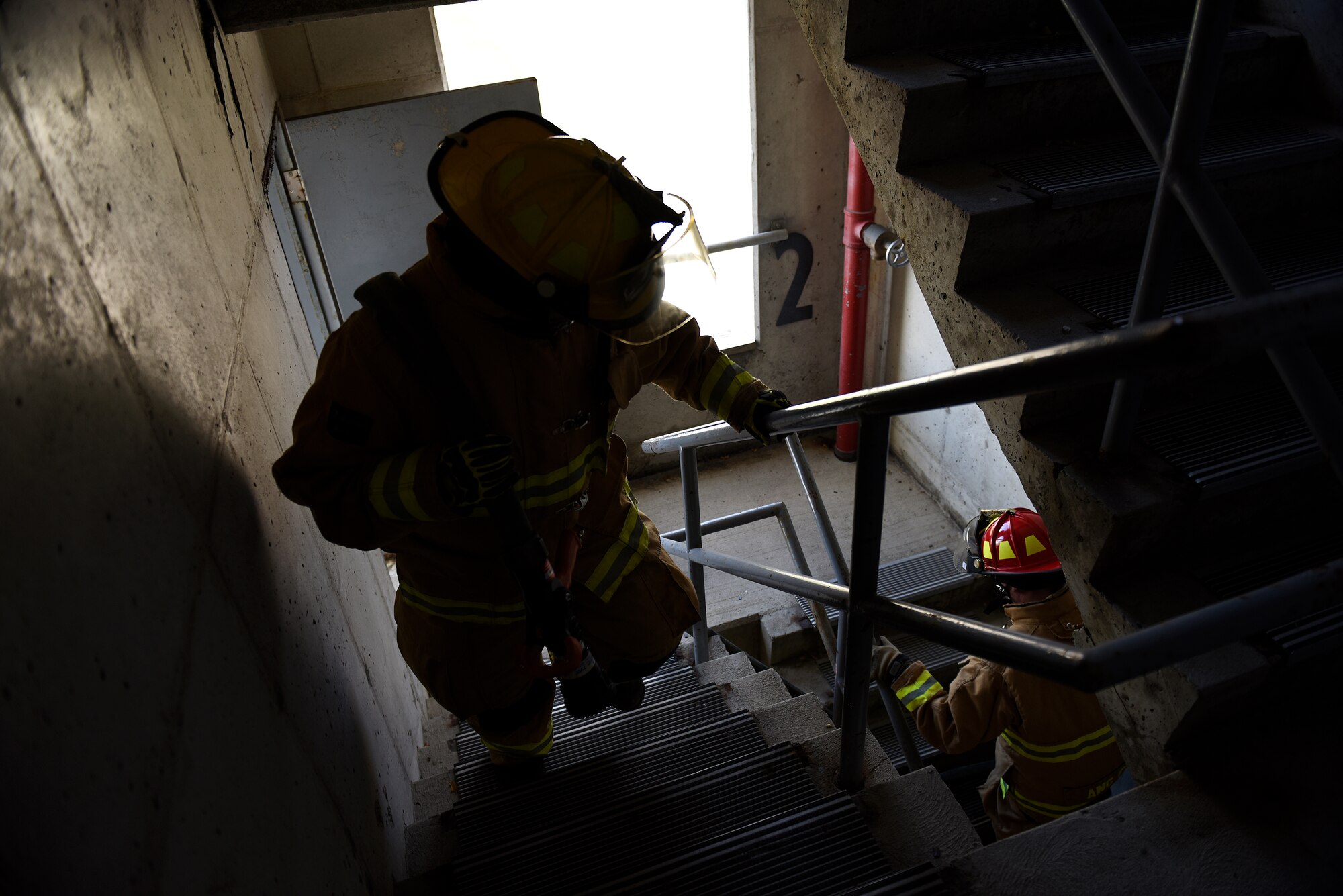 U.S. Air National Guard firefighters assigned to the 180th Fighter Wing ascend a stairwell while carrying a firehose during a Regularly Scheduled Drill training exercise Nov. 7, 2015 in Swanton, Ohio. The firefighters trained on hose advancements in a five-story building during a simulated structure fire. (U.S. Air National Guard photo by Staff Sgt. Shane Hughes/Released)