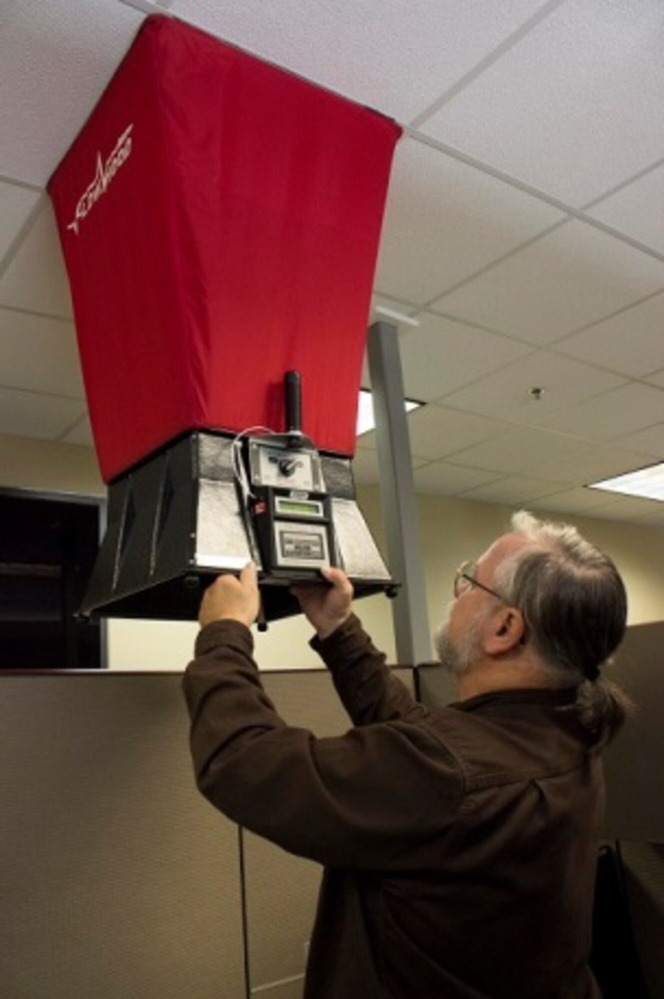 Jeff Fogarty, the HVAC equipment specialist at the Civil Engineer Maintenance Inspection Repair Team at Tyndall Air Force Base, Florida, uses an air flow hood with an air data meter at AFNORTH to balance the system to the original design. (U.S. Air Force Photo/Susan Lawson/Released)