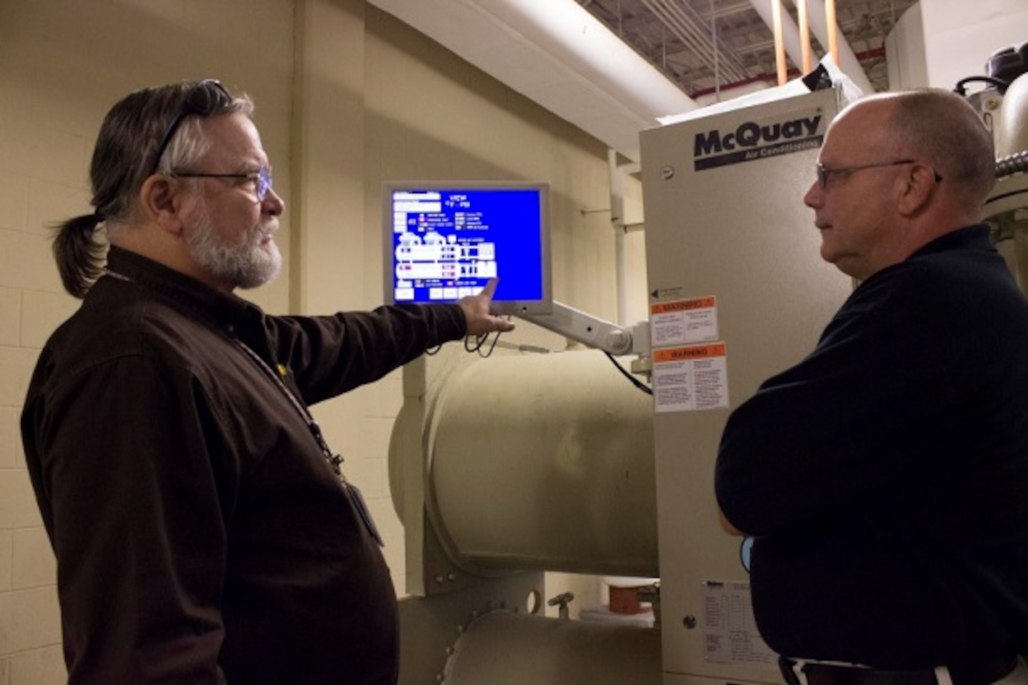 Jeff Fogarty, the HVAC equipment specialist at Civil Engineer Maintenance Inspection Repair Team at Tyndall Air Force Base, Florida, explains the status of the liquid cooled water chiller to Wayne Terrillion, facility manager at AFNORTH. (U.S. Air Force Photo/Susan Lawson/Released)