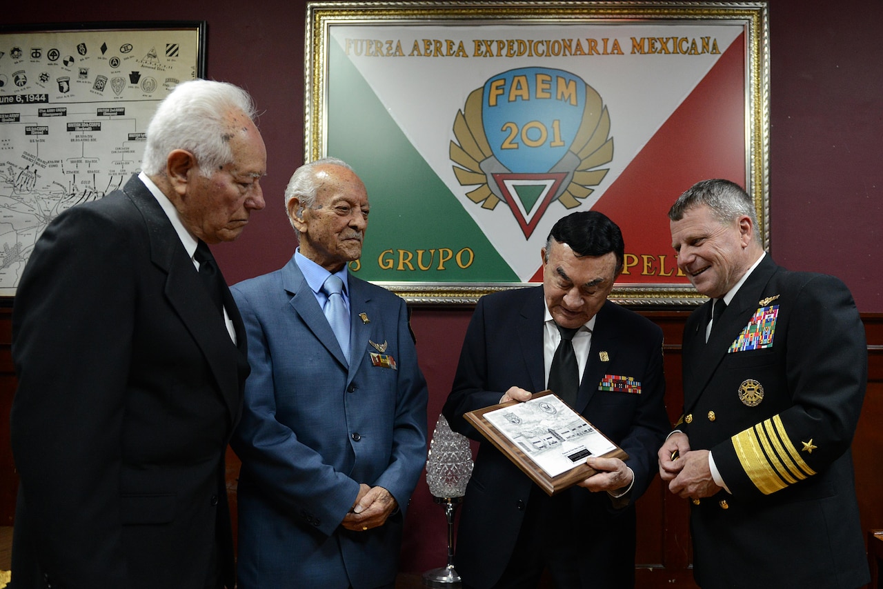 Navy Adm. Bill Gortney, the commander of the North American Aerospace Defense Command and U.S. Northern Command, meets in Mexico City with Mexican air force veterans of the 201st Squadron, which fought alongside the United States in World War II, Nov. 13, 2015. The veterans are, from left, retired Capt. Jose Arroyo García, retired 1st Lt. Heriberto Canete Lopez and retired Capt. Fernando Nava y Musa. The veterans, who were guests of Gortney at a lunch at the American Legion in the Mexican capital, were looking at a plaque the admiral presented to them that shows the NORAD-Northcom headquarters in Colorado Springs, Colo. DoD photo by Lisa Ferdinando
