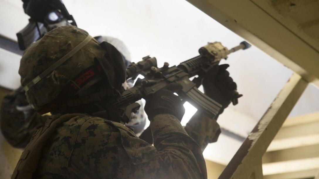 Lance Cpl. Alexis Vergara clears a stairway before his fire team moves to the second floor in a building in Central Training Area’s Combat Town in Okinawa, Japan, Nov. 6 2015. The Marines with Combat Logistic Battalion 31, 31st Marine Expeditionary Unit, used special effect small-arms marking system rounds and cleared buildings with opposing forces during a three day training event. Vergara, a native of Chino Hills, California, is a military policeman with Military Police Detachment, CLB 31, 31st MEU. 