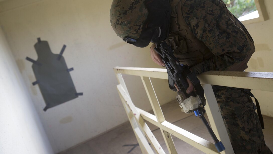 Lance Cpl. David Gamble acts as the opposing force hiding inside a building while a fire team of Marines clear it and search for a hostage in Central Training Area’s Combat Town in Okinawa, Japan, Nov. 6, 2015. Both sides used special effect small-arms marking system rounds to create a more realistic environment because they can see where their shots land. Gamble is from Dallas, Texas, and is a military policeman with Military Police Detachment, Combat Logistic Battalion 31, 31st Marine Expeditionary Unit. 