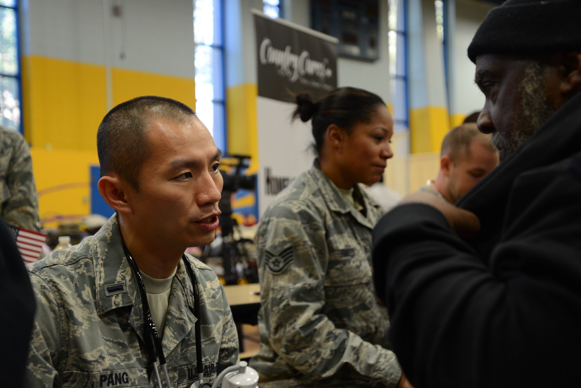 1st Lt. Stan Pang, 108th Medical Group, New Jersey Air National Guard, checks the blood pressure of a homeless veteran at the New Jersey Department of Military and Veterans Affairs Stand Down Day at the John F. Kennedy recreation center in Newark, N.J. On Oct. 10, 2015. The stand down day allows the veterans to get much needed care and services from a wide array of state agencies and nonprofit organizations. Members of the 108th Medical Group have been providing care at stand down days for more than 10 years and were providing blood pressure checks as a means to have conversations with the veterans about their overall health and wellness. Stand Down is a military term referring to exhausted combat units that were removed from the battlefront to a place of security and safety for rest and recovery. Today, Stand Downs are grass roots, community-based intervention program to help veterans' battle life on the streets. (U.S. Air National Guard photo by Master Sgt. Carl Clegg, Released)

