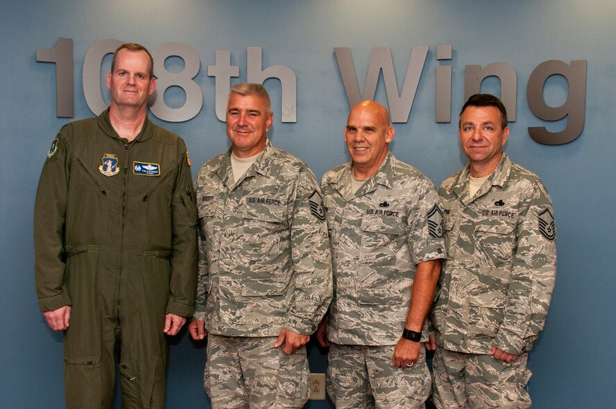 Col. Thomas Coppinger, left, the 108th Operations Group commander, poses with several re-enlisting 108th Wing Airmen in the Wing Headquarters building at Joint Base McGuire-Dix-Lakehurst, N.J., Sept. 19, 2015. From left to right are Master Sgt. Steven Wescott, Senior Master Sgt. Eric Smith and Master Sgt. Michael Ping. (U.S. Air National Guard photo by Airman 1st Class Julia Pyun/Released)