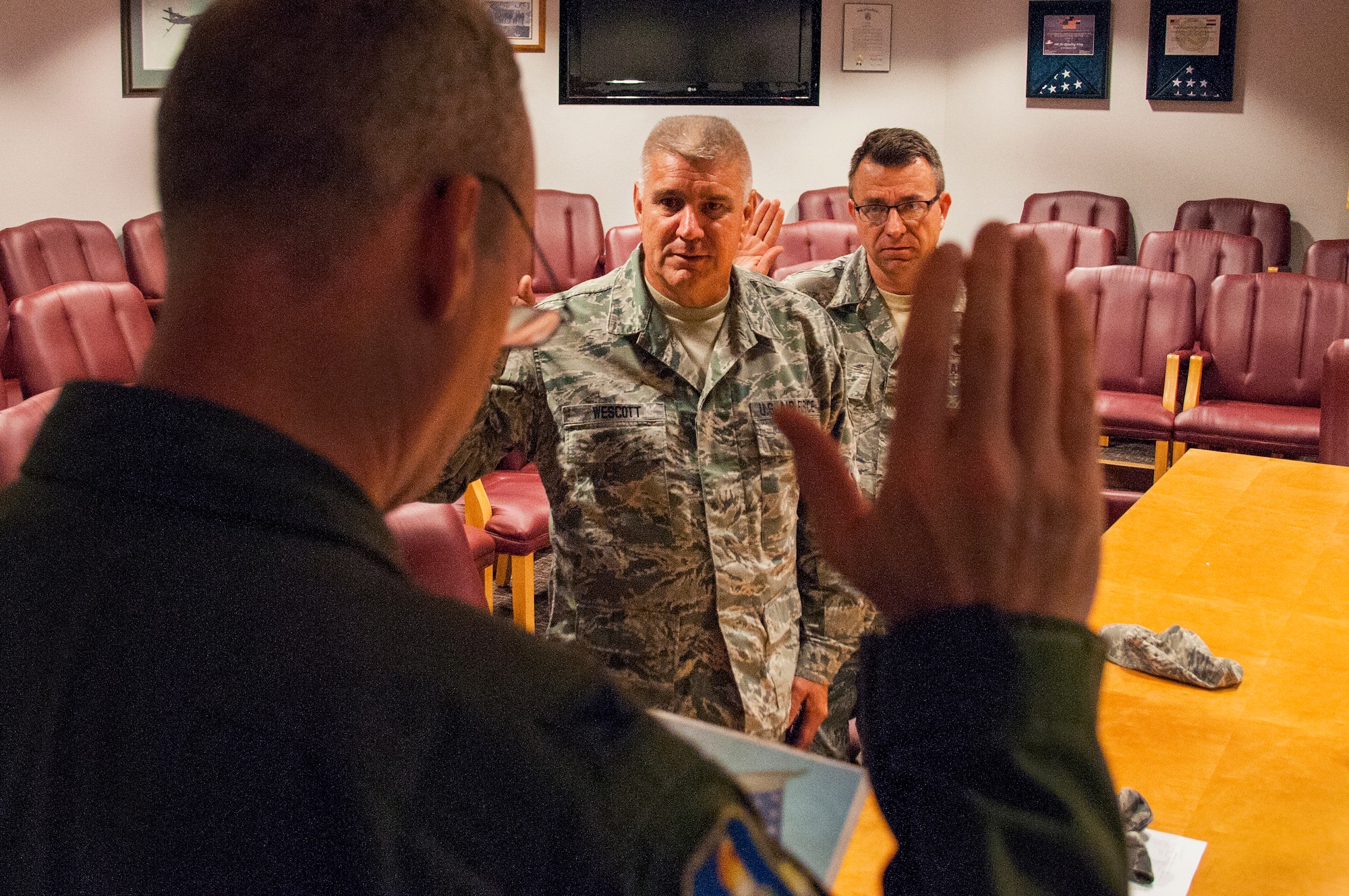 Col. Thomas Coppinger, front, administers the Oath of Enlistment for Master Sgt. Steven Wescott, center, and Master Sgt. Michael Ping to recite in the 108th Wing's conference room at Joint Base McGuire-Dix-Lakehurst, N.J., Sept. 19, 2015. Airmen from the wing can reenlist for an additional 1-6 years. (U.S. Air National Guard photo by Airman 1st Class Julia Pyun/Released)