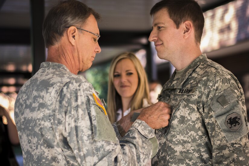 Retired Brig. Gen. Blake Williams pins his son, Maj. Mark Williams, with his new rank during his promotion ceremony on Oct. 18, 2015. Blake Williams and his sons, Mark Williams and Capt. Ryan Williams (not shown) have over four decades of service in the Army Reserve. The elder Williams previously served in the 108th Training Command (IET), the same unit both his sons are currently assigned to. (Photo by Sgt. Ken Scar, 108th Training Command (IET), Public
Affairs)