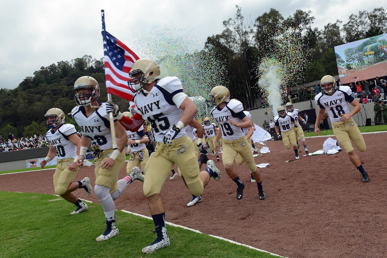 Midshipmen with the United States Naval Academy's Sprint football team rush out to the field at the Mexican Sedena Heroico Colegio Militar for an exhibition game with their Mexican counterparts in Mexico City, Mexico, Nov. 14, 2015. DoD photo by Lisa Ferdinando