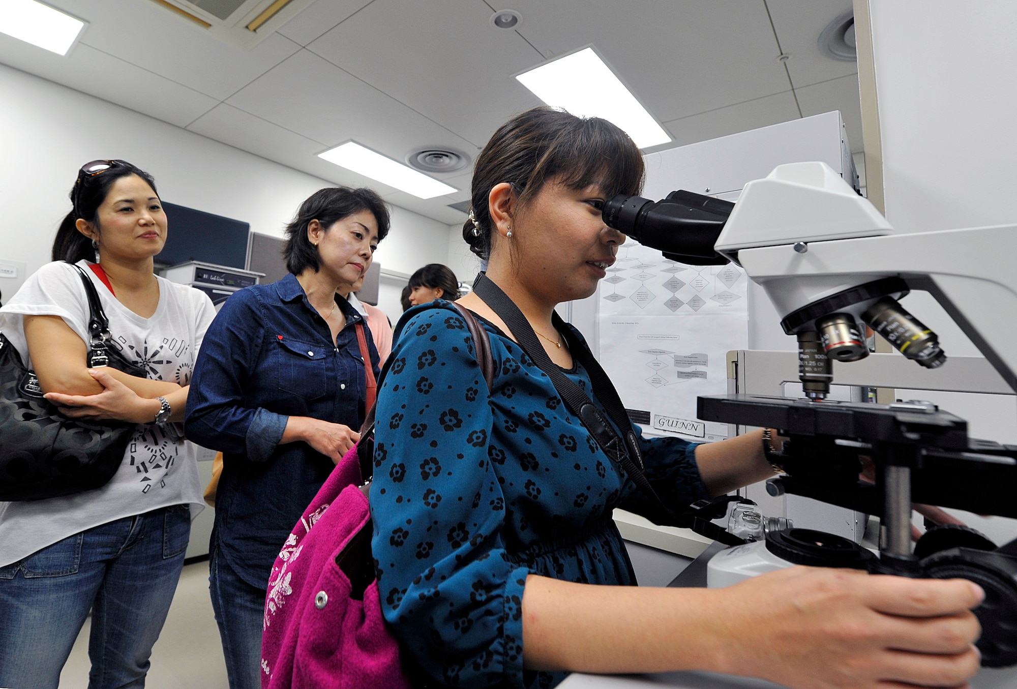 A local interpreter student looks at bacteria through a microscope Nov. 13, 2015, at Kadena Air Base, Japan. Eighteen students from the local hospitals who take an English training course conducted by the Council of Bankoku Iryo Shinryo learned more about English conversation skills while gaining a better understanding of the military medical mission during their visit. (U.S. Air Force photo by Naoto Anazawa)