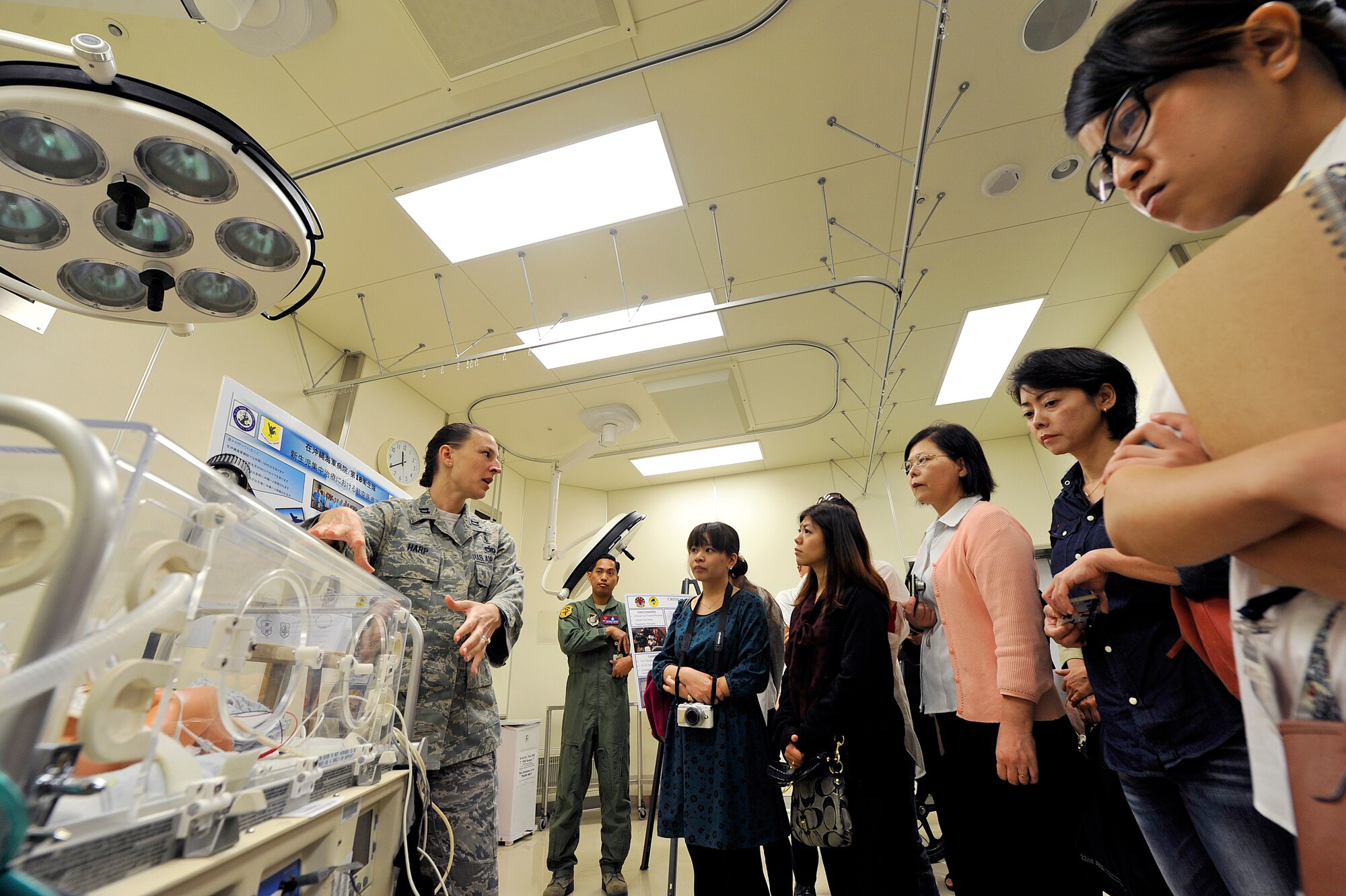 U.S. Air Force Capt. Angela Harp, 18th Medical Operations Squadron neonatal intensive care unit nurse, explains a nuchal transport system to local medical interpreter students, Nov. 13, 2015, at Kadena Air Base, Japan. Eighteen students from the local hospitals who take an English training course conducted by the Council of Bankoku Iryo Shinryo learned more about English conversation skills while gaining a better understanding of the military medical mission during their visit. (U.S. Air Force photo by Naoto Anazawa)