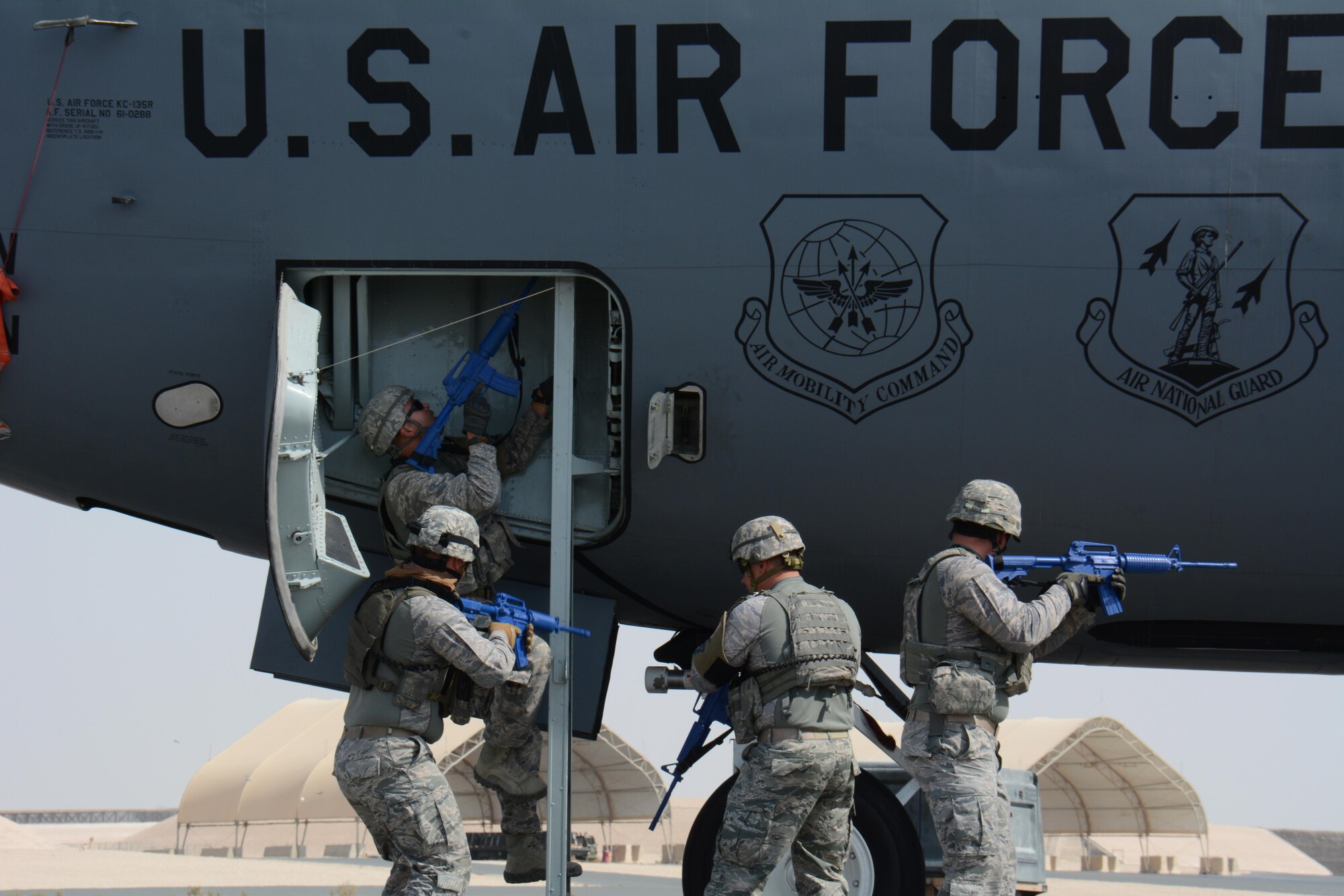 Airmen from the 379th Expeditionary Security Forces Squadron tactically approach the entrance of a KC-135 Stratotanker during a force protection exercise at Al Udeid Air Base, Qatar Nov. 12. The exercise featured U.S. Air Force airmen and Qatar Emir Air Force airmen working together to apprehend the suspect of an attempted aircraft hijacking. (U.S. Air Force photo by Tech. Sgt. James Hodgman)