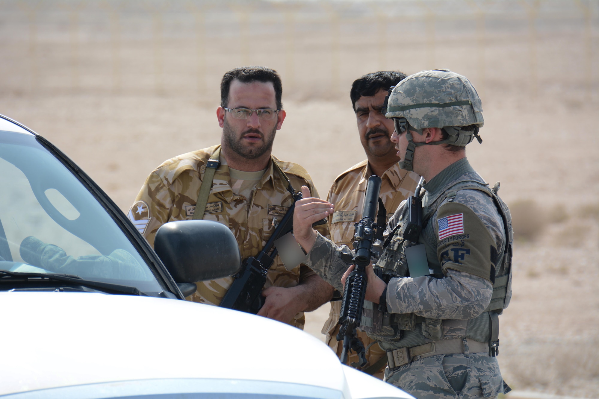 Qatar Emir Air Force airmen discuss security tactics with a 379th Expeditionary Security Forces Squadron airman at Al Udeid Air Base, Qatar Nov. 12 during a force protection exercise. The exercise consisted of an attempted aircraft hijacking and featured U.S. Air Force airmen and QEAF airmen working together to apprehend the suspect. (U.S. Air Force photo by Tech. Sgt. James Hodgman)