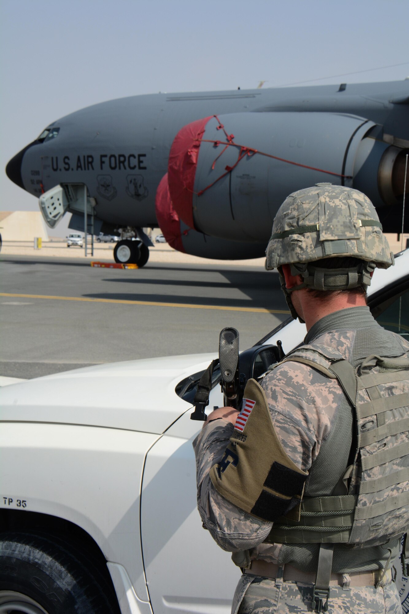 A 379th Expeditionary Security Forces Squadron airman keeps an eye on a KC-135 Stratotanker from behind the protection of his truck during a force protection exercise at Al Udeid Air Base, Qatar Nov. 12. The exercise, which featured participation from U.S. airmen, as well as airmen from the Qatar Emir Air Force, consisted of an attempted aircraft hijacking. (U.S. Air Force photo by Tech. Sgt. James Hodgman) 