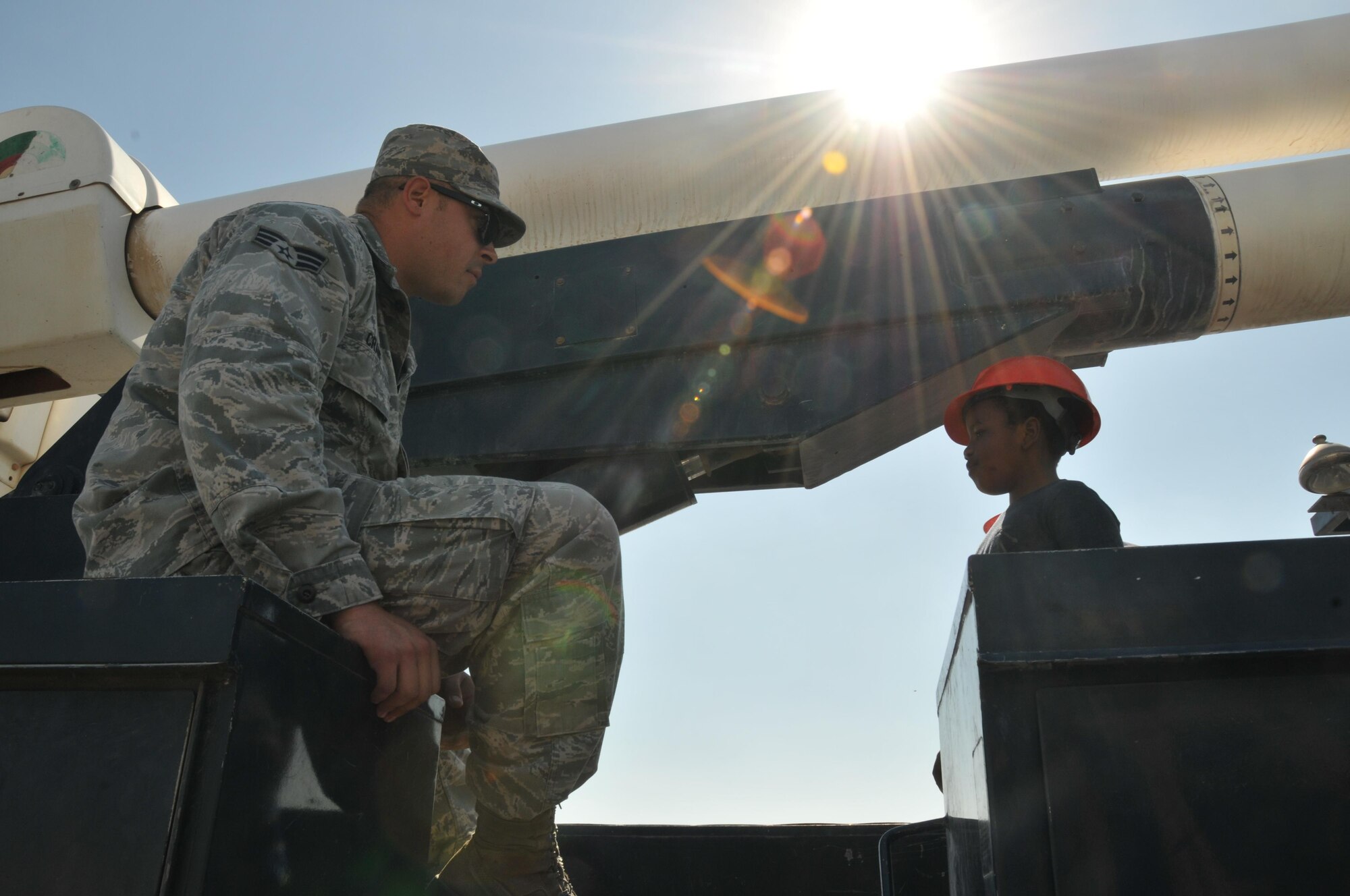 Electricians from the 379th Expeditionary Civil Engineer Squadron came to support the military family event with their bucket truck Nov. 14 at Al Udeid Air Base, Qatar. Senior Airman David Crane discussed his job and the bucket truck with military family members. Crane also gave family members a chance to get inside the bucket. (U.S. Air Force photo by Tech. Sgt. Terrica Y. Jones/Released)