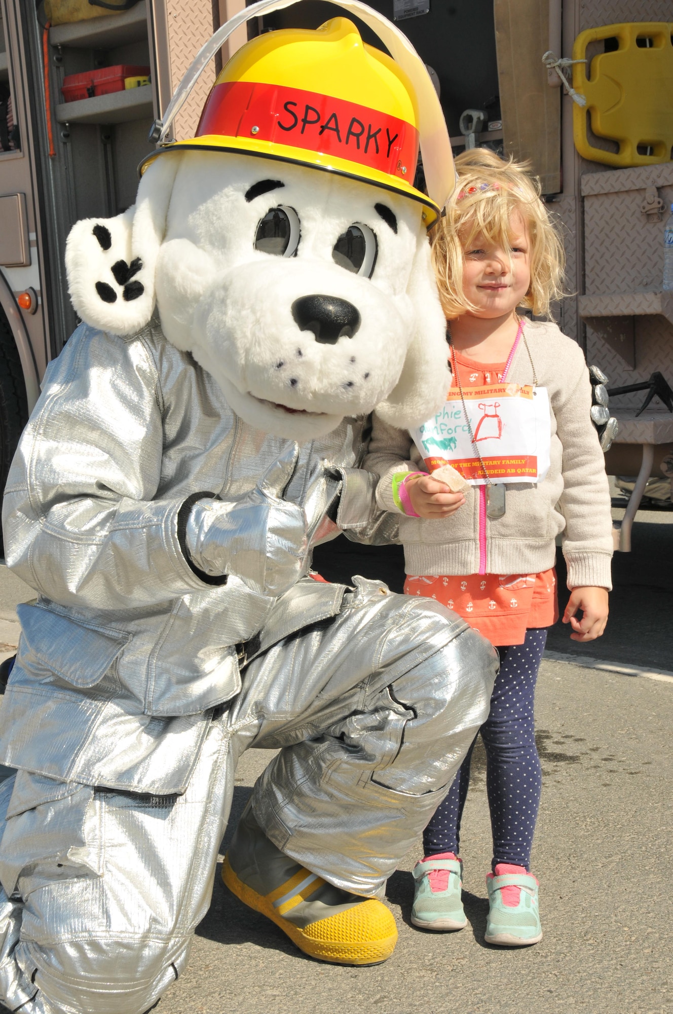 Sparky the Firedog showed his support at the military family event Nov. 14 at Al Udeid Air Base, Qatar. Sparky handed out candy to kids who visited the firetruck. Firefighter tools were also displayed in front of the truck for participants to view and handle. (U.S. Air Force photo by Tech. Sgt. Terrica Y. Jones/Released)
