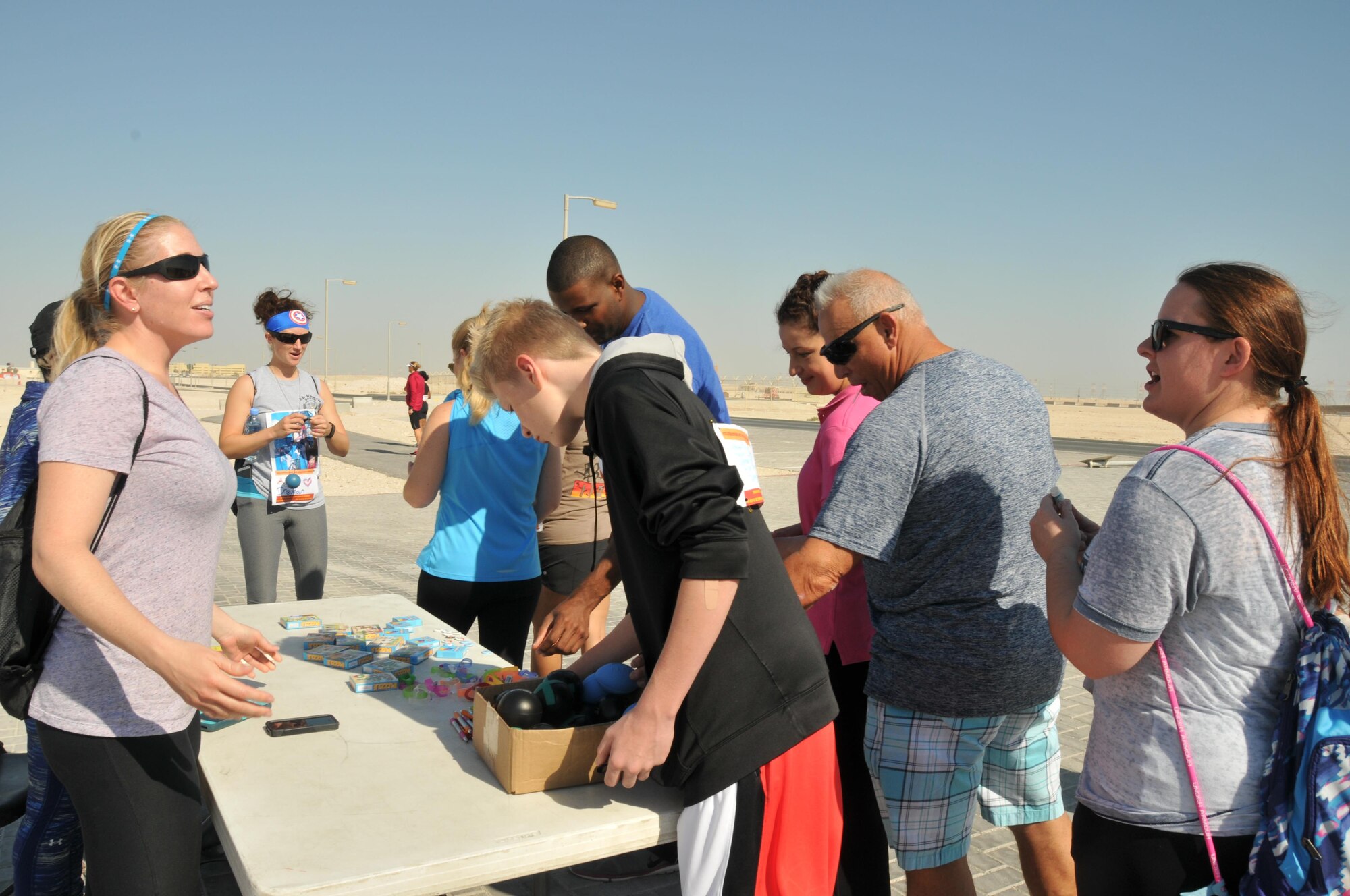 The 379th Expeditionary Force Support Squadron Airmen and Family Readiness center provides trinket tables for the Nov. 14 Family Walk at Al Udeid Air Base, Qatar.  Each station had different items participants could choose from as they walked the 2-mile loop. Four families came out to support the event. (U.S. Air Force photo by Tech. Sgt. Terrica Y. Jones/Released)