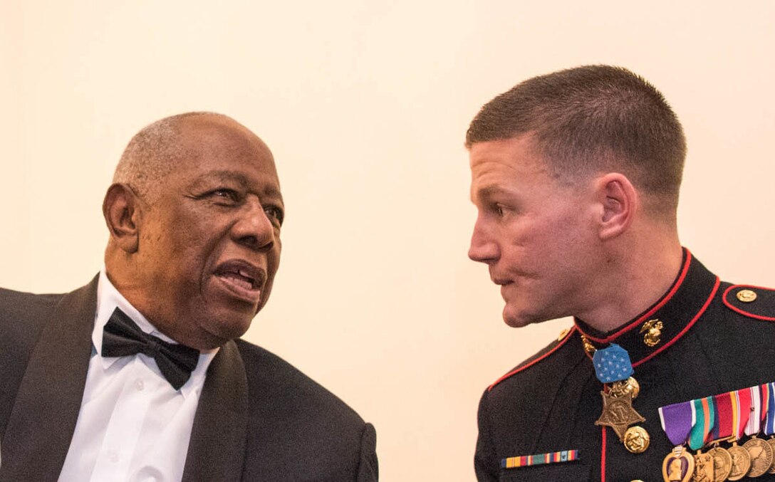 Baseball Hall of Famer Hank Aaron talks with Marine Corps Cpl. Kyle Carpenter at the National Portrait Gallery in Washington, D.C., Nov. 15, 2015. Both men received the Portrait of a Nation Prize during an event at the museum. DoD photo by D. Myles Cullen