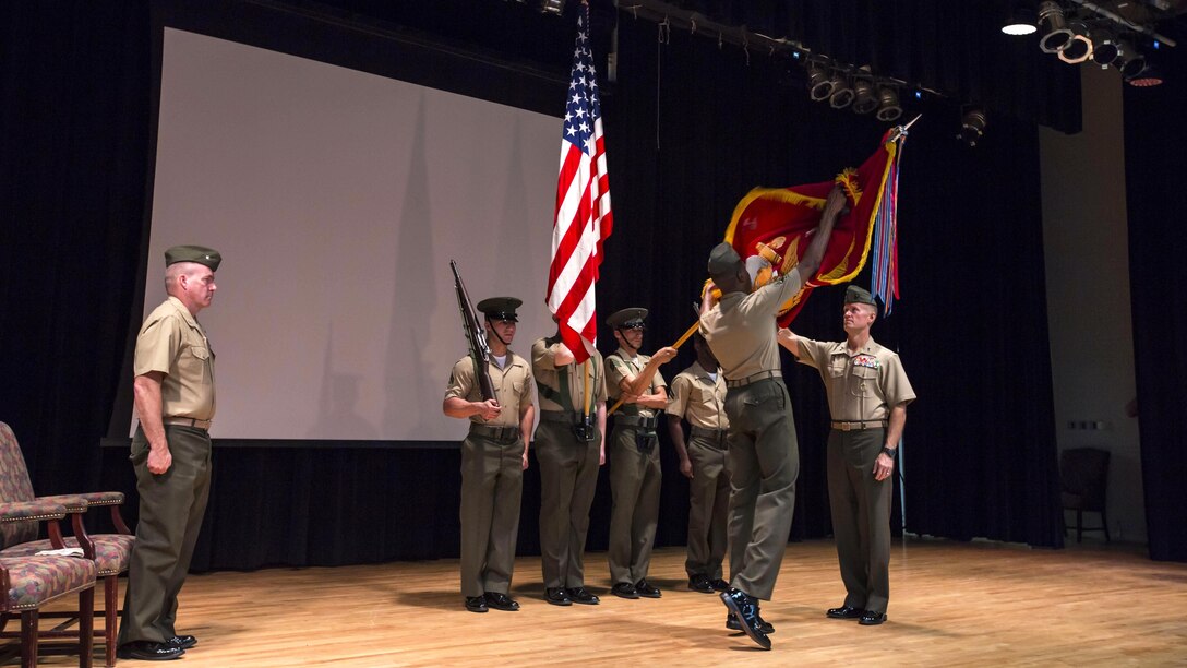 U.S. Marine Corps Sgt. Maj. Clifford W. Wiggins, 5th Marine Expeditionary Brigade sergeant major , second from right, and Maj. Gen. Carl E. Mundy III, 5th Marine Expeditionary Brigade commanding general, far right, both with the 5th Marine Expeditionary Brigade unfurl the unit colors during the activation ceremony of the 5th MEB at Naval Support Activity Bahrain, Oct. 15, 2015. Command Element Marine Forces Central Command Forward was re-designated as the 5TH MEB to more accurately reflect Marine Corps organizational doctrine, and will continue to provide a forward-deployed headquarters in the U.S. Central Command area of responsibility