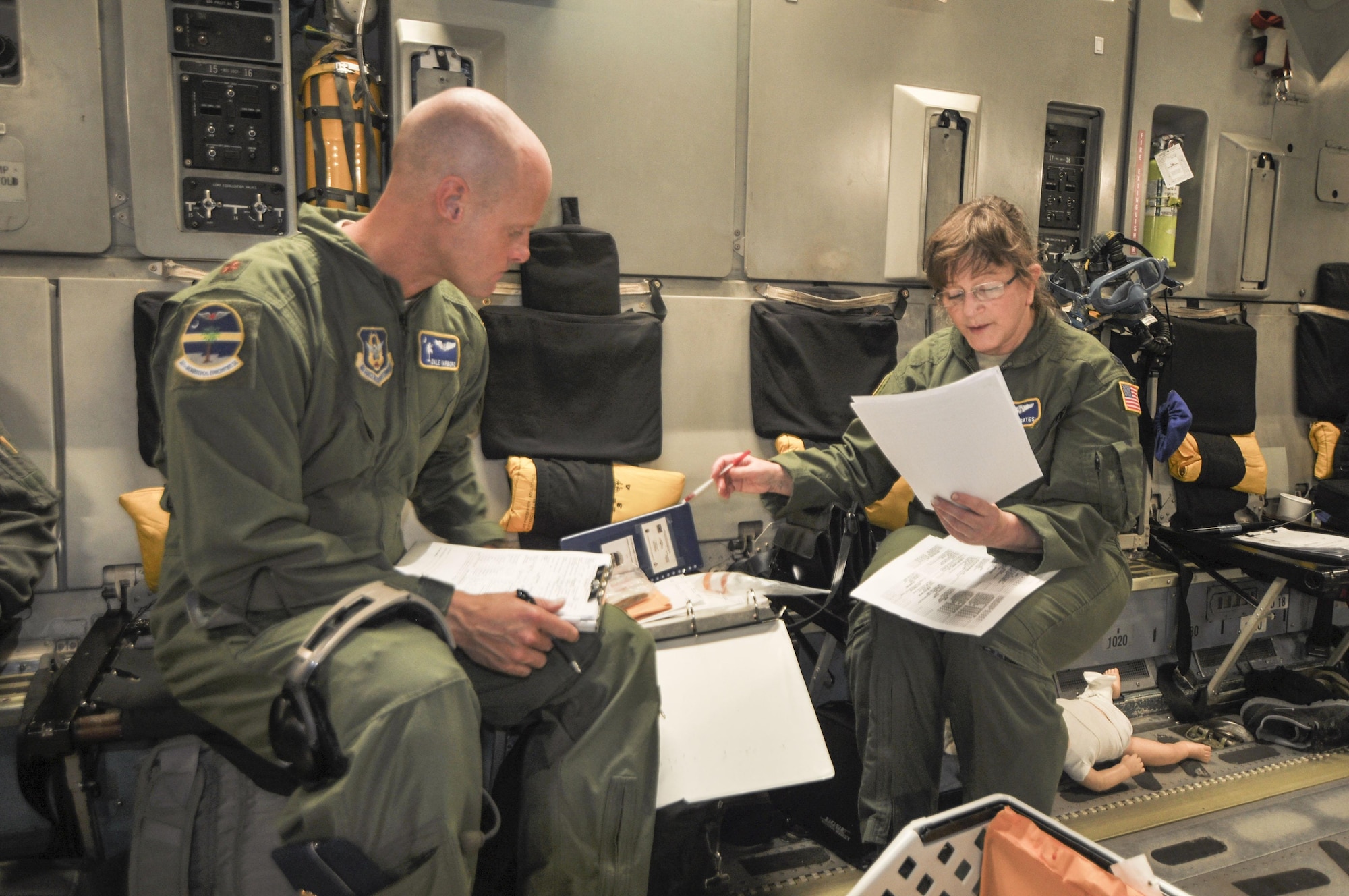 Col. Sunny Gates (right), director of operations for the 315th Aeromedical Evacuation Squadron at Joint Base Charleston goes over medical procedures with Maj. Dale Yarboro on a recent off-station training mission. (U.S. Photo by Maj. Wayne Capps)