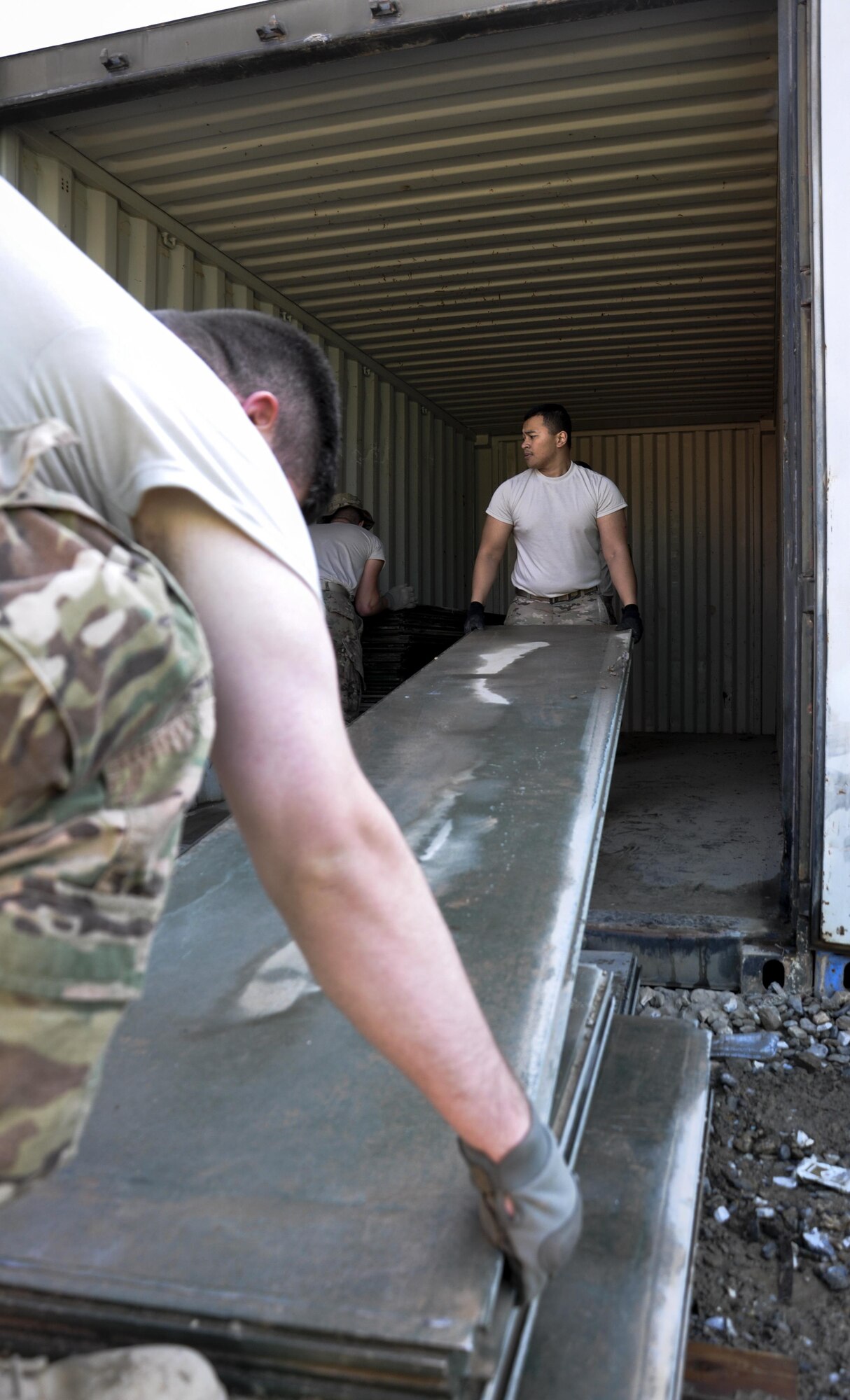 Airman 1st Class John Aradanas, right, Central Command Materiel Recovery Element team member, deployed from McChord Air Force Base, Wash., alongside his CMRE team member, slide aircraft ground paneling into storage for redeployment at Bagram Airfield, Afghanistan, Nov. 13, 2015. The CMRE team is designed to account for and redeploy war reserve assets after they have fulfilled their intended purpose, so they are available for use elsewhere. (U.S. Air Force photo by Tech. Sgt. Nicholas Rau/Released)