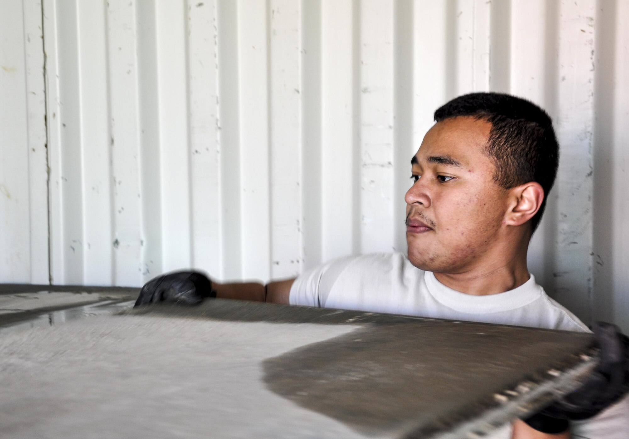 Airman 1st Class John Aradanas, right, Central Command Materiel Recovery Element team member, deployed from McChord Air Force Base, Wash., alongside his CMRE team member, slide aircraft ground paneling into storage for redeployment at Bagram Airfield, Afghanistan, Nov. 13, 2015. The CMRE team is designed to account for and redeploy war reserve assets after they have fulfilled their intended purpose, so they are available for use elsewhere. The team worked numerous hours over six days to manually move 480,852 pounds of material, consolidate 29 shipping containers, and inventory nearly 81,000 square feet of the matting worth $1.5 million. (U.S. Air Force photo by Tech. Sgt. Nicholas Rau/Released)
