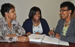 Defense Logistics Agency Equal Employment Opportunity Technician Charnika Hayes, center, discusses with her mentors DLA EEO Staff Director Janice Samuel, left, and DLA EEO Deputy Director Bridget Lanier, right, her new roles and responsibilities during the six-month rotation with DLA EEO.