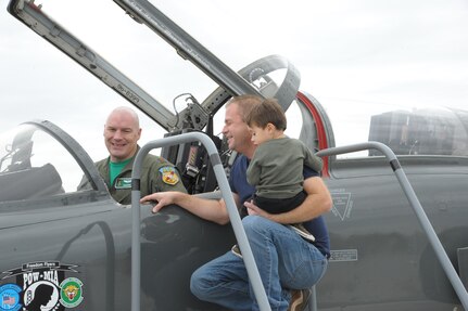 Maj. Vince Sherer, 560th Flying Training Squadron, student instructor, shows the T-38 Talon aircraft to Matthew Juliar and his son Joshua, during the Joint Base San Antonio Seguin Auxiliary Airfield Open House, Nov. 13, 2015. JBSA-Randolph Auxiliary Airfield is used solely by the 560th Flying Training Squadron for preparing instructors for undergraduate pilot training T-38 training assignments.  The 560th primarily uses Seguin Auxfield for practice landings in a pilot controlled pattern called instead of FAA controllers. (U.S. Air Force photo by Joel Martinez/Released) 