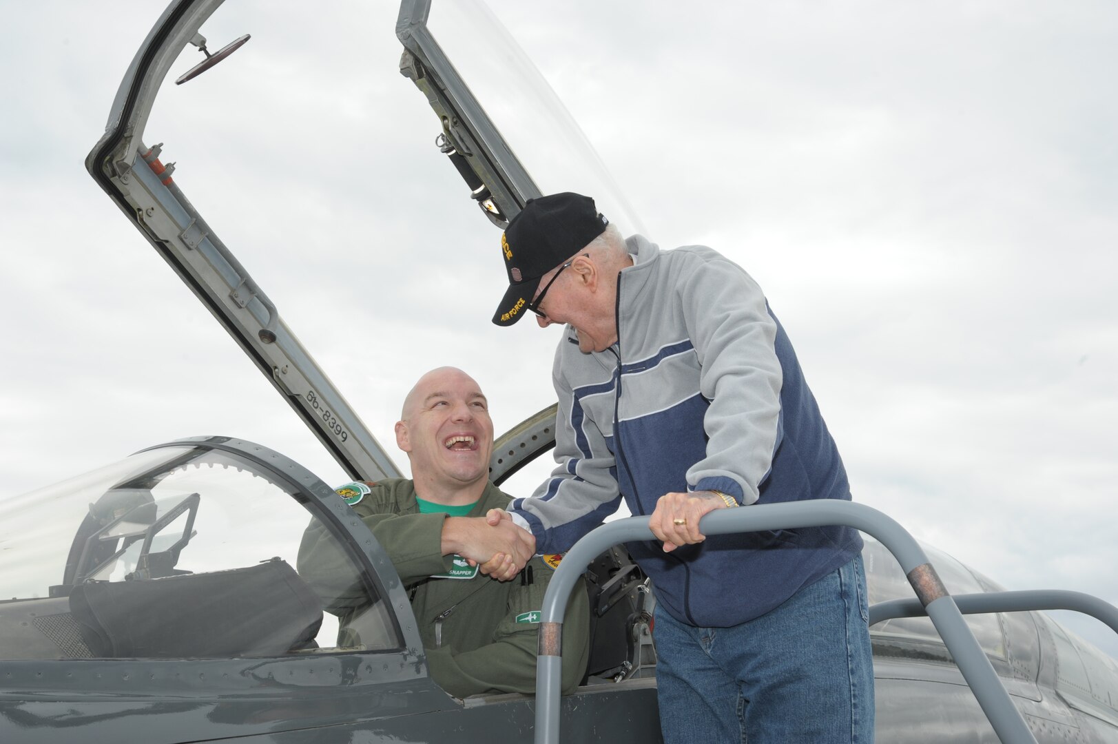 Maj. Vince Sherer, 560th Flying Training Squadron, student instructor, greets Chaplain Lt. Col. Ret. Kenyon Hutchenson, during the Joint Base San Antonio Seguin Auxiliary Airfield Open House, Nov. 13, 2015. JBSA-Randolph Auxiliary Airfield is used solely by the 560th Flying Training Squadron for preparing instructors for undergraduate pilot training T-38 training assignments.  The 560th primarily uses Seguin Auxfield for practice landings in a pilot controlled pattern called instead of FAA controllers. (U.S. Air Force photo by Joel Martinez/Released) 