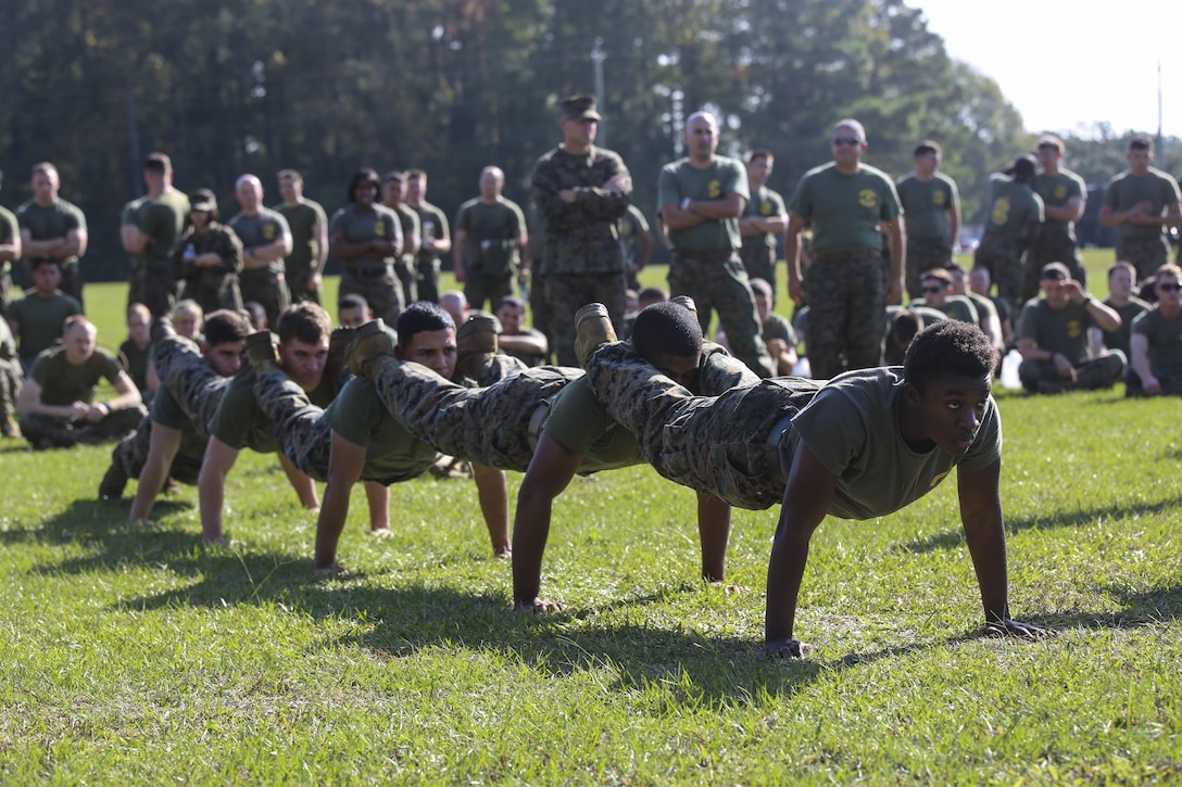 Marines with 8th Communication Battalion compete in squad push-ups during a field meet at Camp Lejeune, N.C., Nov. 6, 2015. 8th Comm. Bn. provides the unique ability to deploy task-organized communication detachments capable of installing, operating, maintaining and defending communication networks in support of II Marine Expeditionary Force. (U.S. Marine Corps photo by Cpl. Paul S. Martinez/Released)