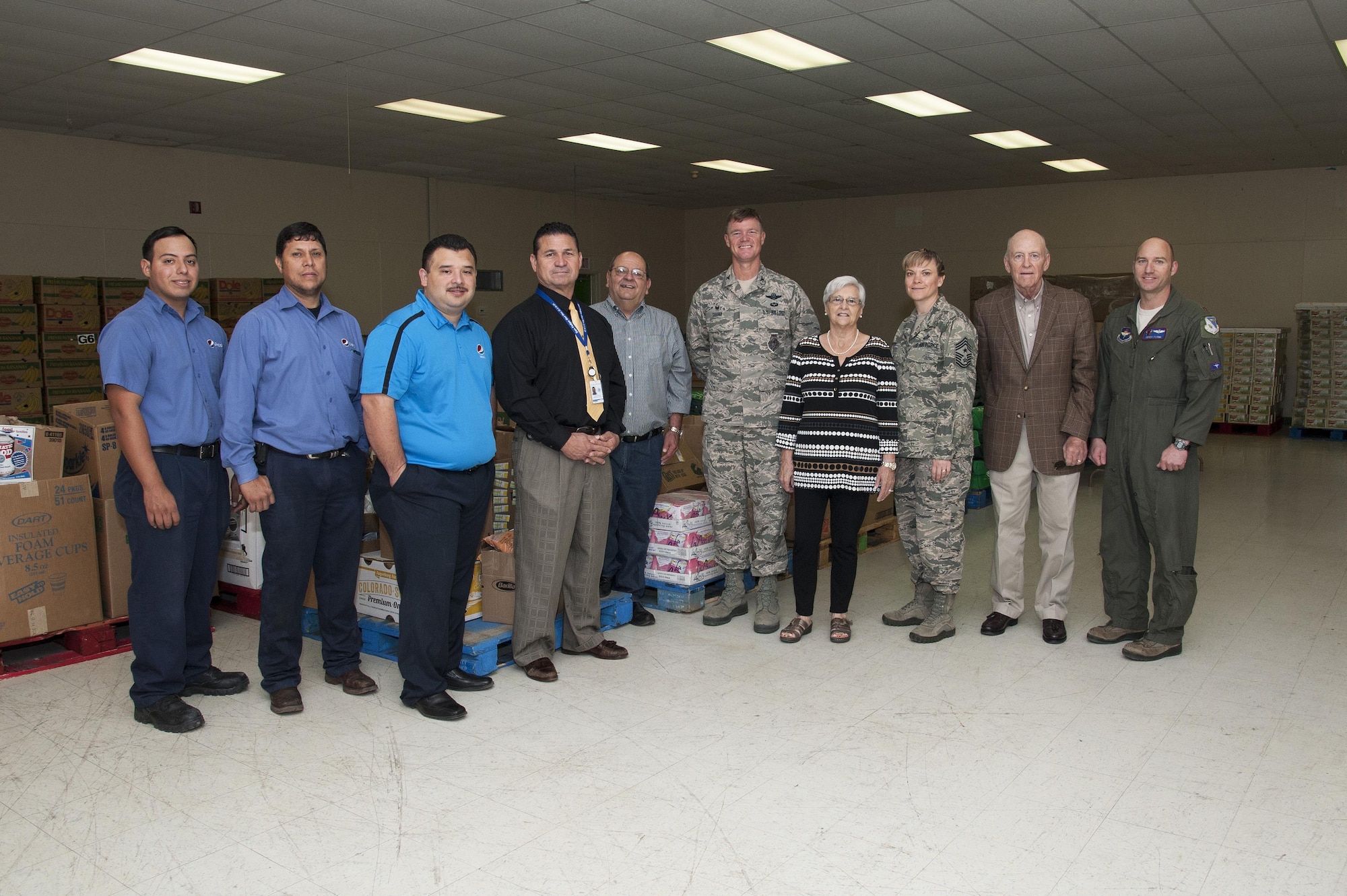 Col. Thomas Shank, 47th Flying Training Wing commander, and Chief Master Sgt. Teresa Clapper, 47th FTW command chief, pose with community leaders, volunteers and Val Verde Loaves and Fishes food pantry staff in front of food donated as part of the Feds Feed Families campaign in Del Rio, Texas, Nov. 12, 2015. Shank and Clapper were on hand to celebrate the handover of more than 24,000 pounds of non-perishable food items collected by the men and women living and working on Laughlin Air Force Base for the local food bank, which helps feed approximately 18,000 families in and around Del Rio each year. (U.S Air Force photo by Staff Sgt. Nathan Maysonet)    