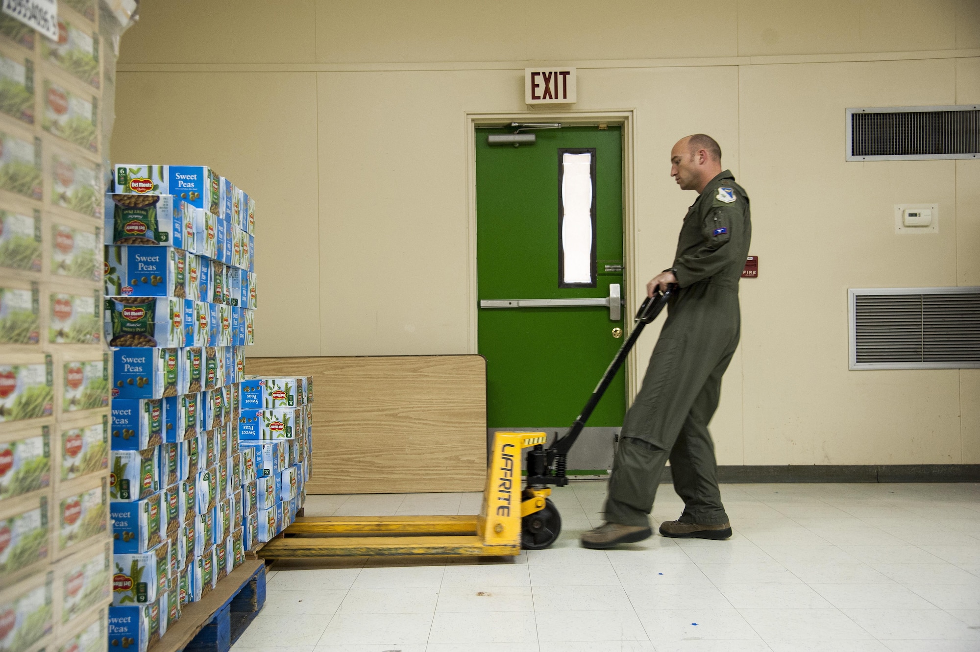 Maj. Derek Flynn, 87th Flying Training Squadron assistant director of operations, moves a pallet of canned goods at the Val Verde Loaves and Fishes food pantry in Del Rio, Texas, Nov. 12, 2015. As part of the Feds Feed Families campaign, Laughlin Air Force Base personnel and their families collected and donated more than 24,000 pounds of non-perishable food items to the food pantry, which is the only local food bank supported by the City of Del Rio, the local school district and Val Verde County. (U.S. Air Force photo by Staff Sgt. Nathan Maysonet)   