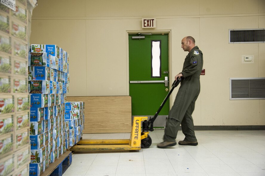 Maj. Derek Flynn, 87th Flying Training Squadron assistant director of operations, moves a pallet of canned goods at the Val Verde Loaves and Fishes food pantry in Del Rio, Texas, Nov. 12, 2015. As part of the Feds Feed Families campaign, Laughlin Air Force Base personnel and their families collected and donated more than 24,000 pounds of non-perishable food items to the food pantry, which is the only local food bank supported by the City of Del Rio, the local school district and Val Verde County. (U.S. Air Force photo by Staff Sgt. Nathan Maysonet)   