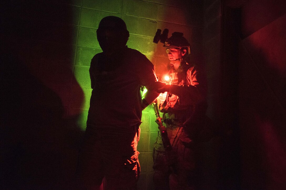 A special operations airman treats and processes rescued hostages during a noncombatant evacuation exercise as part of Southern Strike 16 on Meridian Naval Air Station, Miss., Nov. 3, 2015. New York National Guard photo by Air Force Staff Sgt. Christopher S. Muncy