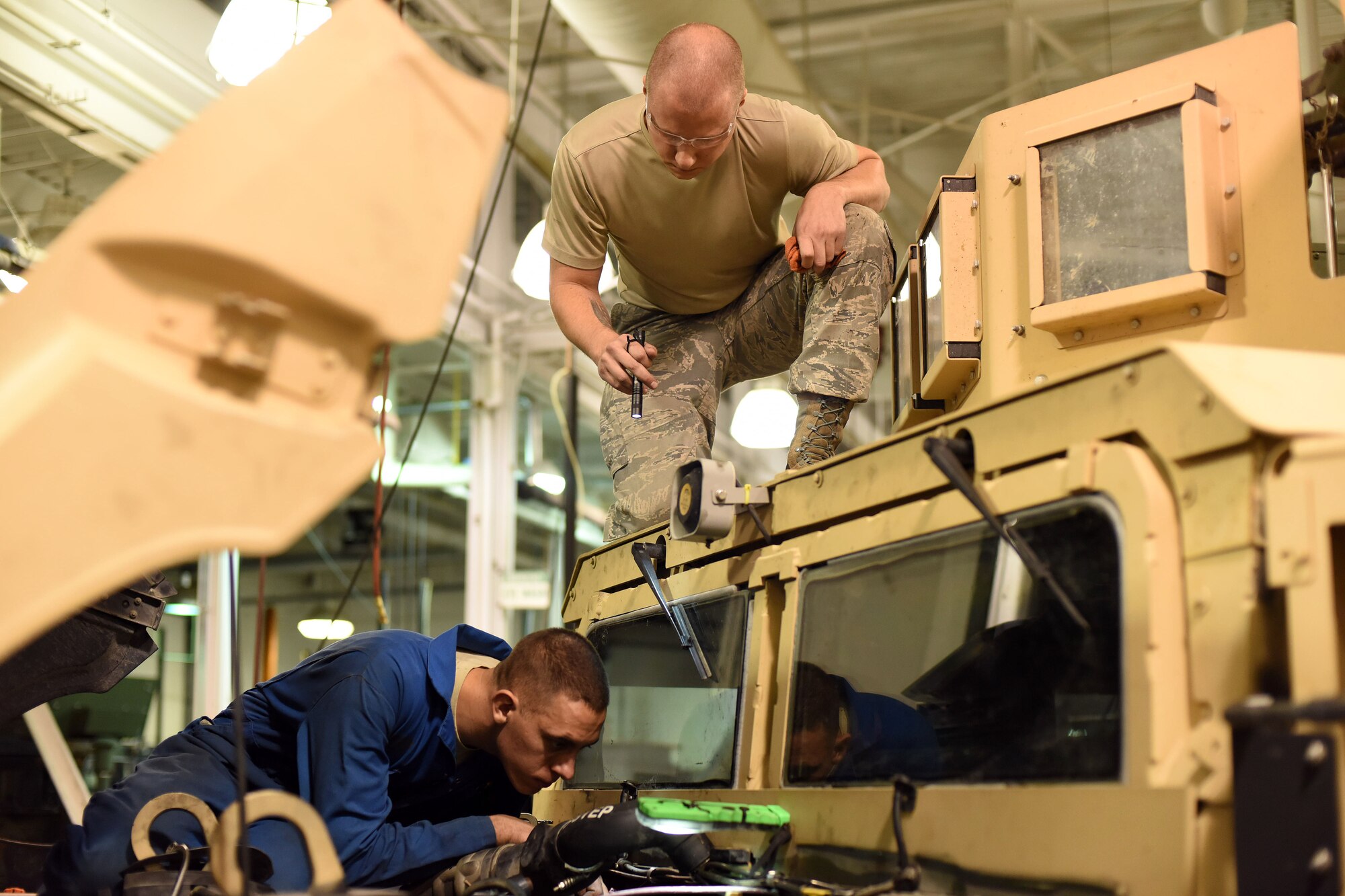 Senior Airman Elliott Packingham, 341st Logistics Readiness Squadron fleet management analyst, shines a light for Senior Airman Zachary Simmons, 341st LRS vehicle maintenance journeyman, as he makes repairs to a Humvee during exercise GLOBAL THUNDER 16, Nov. 6, 2015 at Malmstrom Air Force Base, Mont. Packingham and Simmons repaired the Humvee during a 12-hour shift as part of the exercise. The 341st LRS is part of U.S. Strategic Command’s (USSTRATCOM) Task Force 214 and supports the command’s strategic deterrence mission by operating and maintaining the Air Force’s Intercontinental Ballistic Missile force. GLOBAL THUNDER is an annual U.S. Strategic Command training event that assesses command and control functionality in all USSTRATCOM mission areas and affords component commands a venue to evaluate their joint operational readiness. Planning for GLOBAL THUNDER 16 has been under way for more than a year and is based on a notional scenario with fictitious adversaries. USSTRATCOM, one of nine DoD unified combatant commands, relies on various task forces for the execution of its global missions, which also include space operations; cyberspace operations; joint electronic warfare; global strike; missile defense; intelligence, surveillance and reconnaissance; combating weapons of mass destruction; and analysis and targeting. (U.S. Air Force photo by Airman Collin Schmidt)