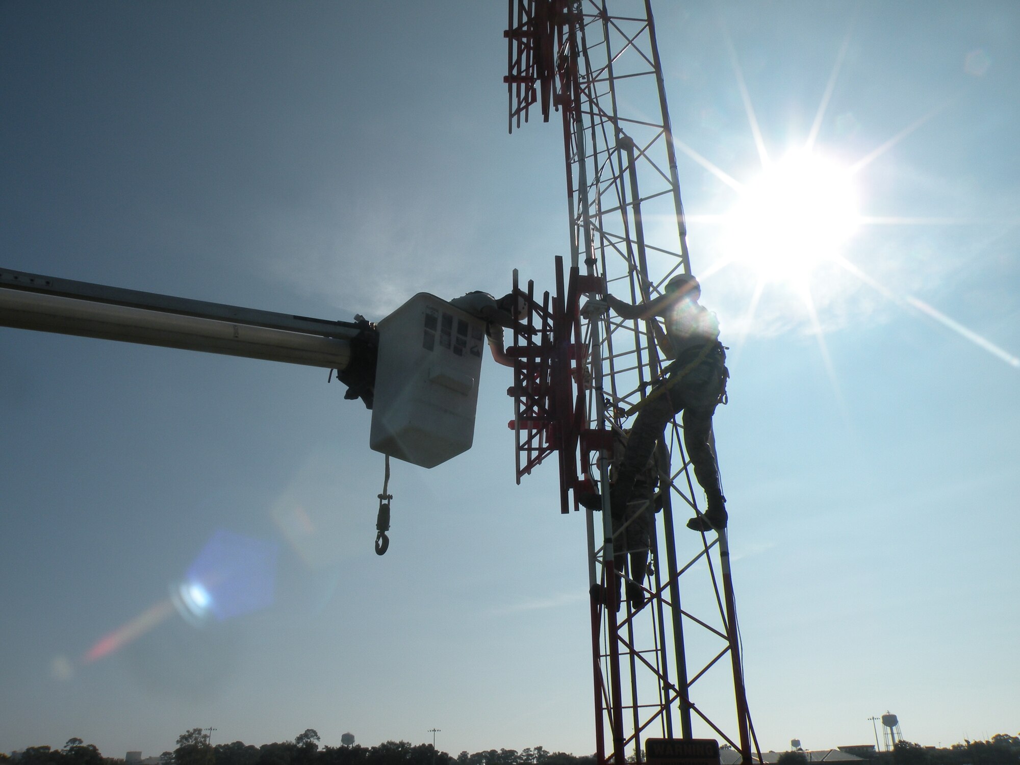 Members of the 85th Engineering Installation Squadron and Headquarters Air Force Flight Standards Agency, Tinker Air Force Base, Okla., work together to replace antennae brackets on the glide slope antennae on the flight line Nov. 12, 2015, Keesler Air Force Base, Miss. The glide slope antenna is part of the instrumental landing system on the flight line. (Courtesy photo by Tech. Sgt. James Anania)