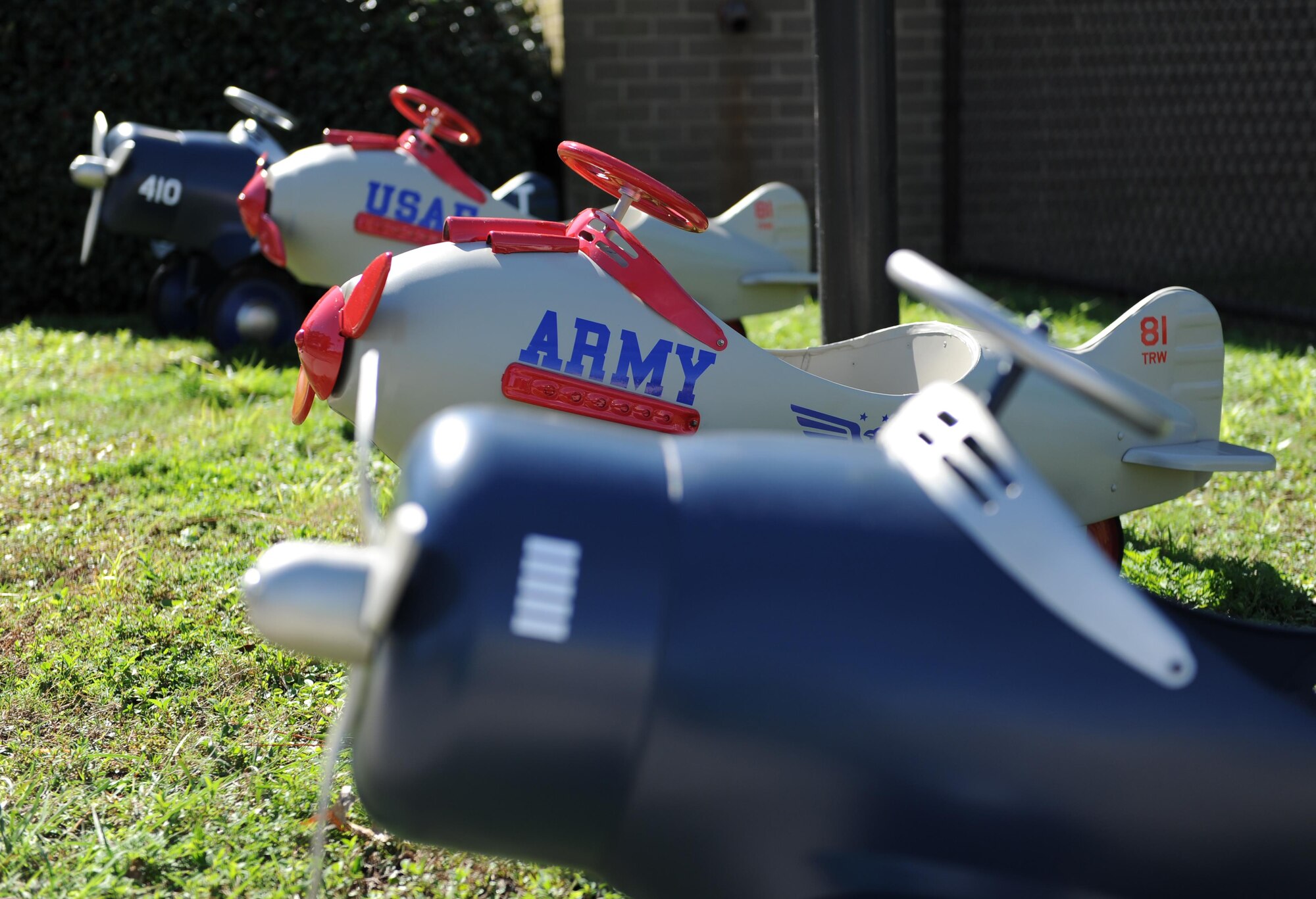 Refurbished pedal airplanes sit in front of the child development center Nov. 13, 2015, Keesler Air Force Base, Miss. The four pedal airplanes, refurbished by the Trainer Development Center, have been in storage for more than 10 years. (U.S. Air Force photo by Kemberly Groue)
