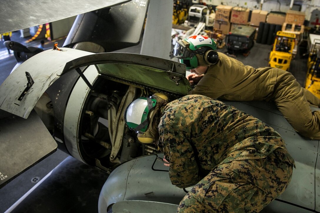 INDIAN OCEAN (Nov. 6, 2015) U.S. Marine Sgt. Taylor Harris shows Sgt. Katelyn Allen how to conduct a maintenance check on an MV-22B Osprey in the hangar bay of the USS Essex (LHD 2). Harris is a non-destructive inspection technician and Allen is an air-traffic controller with Medium Marine Tiltrotor Squadron 161 (Reinforced), 15th Marine Expeditionary Unit. Marines with the MEU’s aviation combat element work together to ensure the aircraft are in good condition and safe to fly. The 15th MEU is currently deployed in the Indo-Asia-Pacific region to promote regional stability and security in the U.S. 7th Fleet area of operations. (U.S. Marine Corps photo by Sgt. Anna Albrecht/Released)