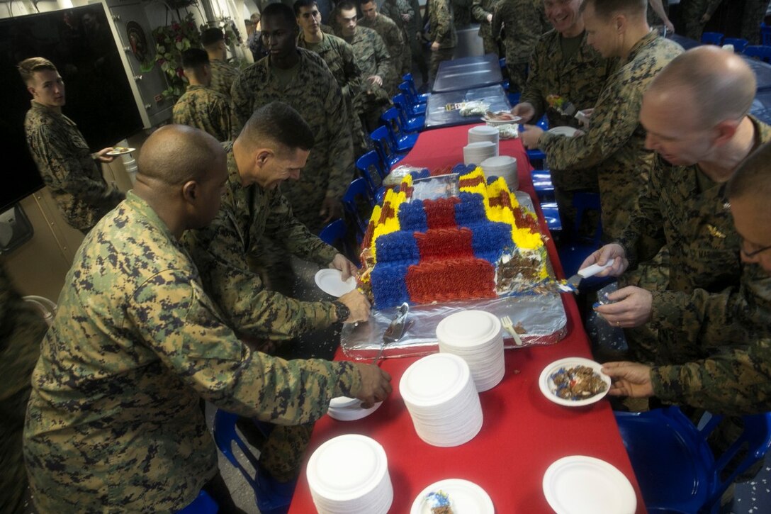 SOUTH CHINA SEA (Nov. 10, 2015) U.S. Marines with the 15th Marine Expeditionary Unit cut pieces of cake for their junior Marines to celebrate the Marines Corps’ 240th birthday aboard the USS Essex (LHD 2). The ceremony included a reading of Gen. John A. Lejeune’s birthday message and a cake-cutting to celebrate 240 years of tradition, service, and victory. The 15th MEU is currently deployed in the Indo-Asia-Pacific region to promote regional stability and security in the U.S. 7th Fleet area of operations. (U.S. Marine Corps photo by Sgt. Anna Albrecht/Released)