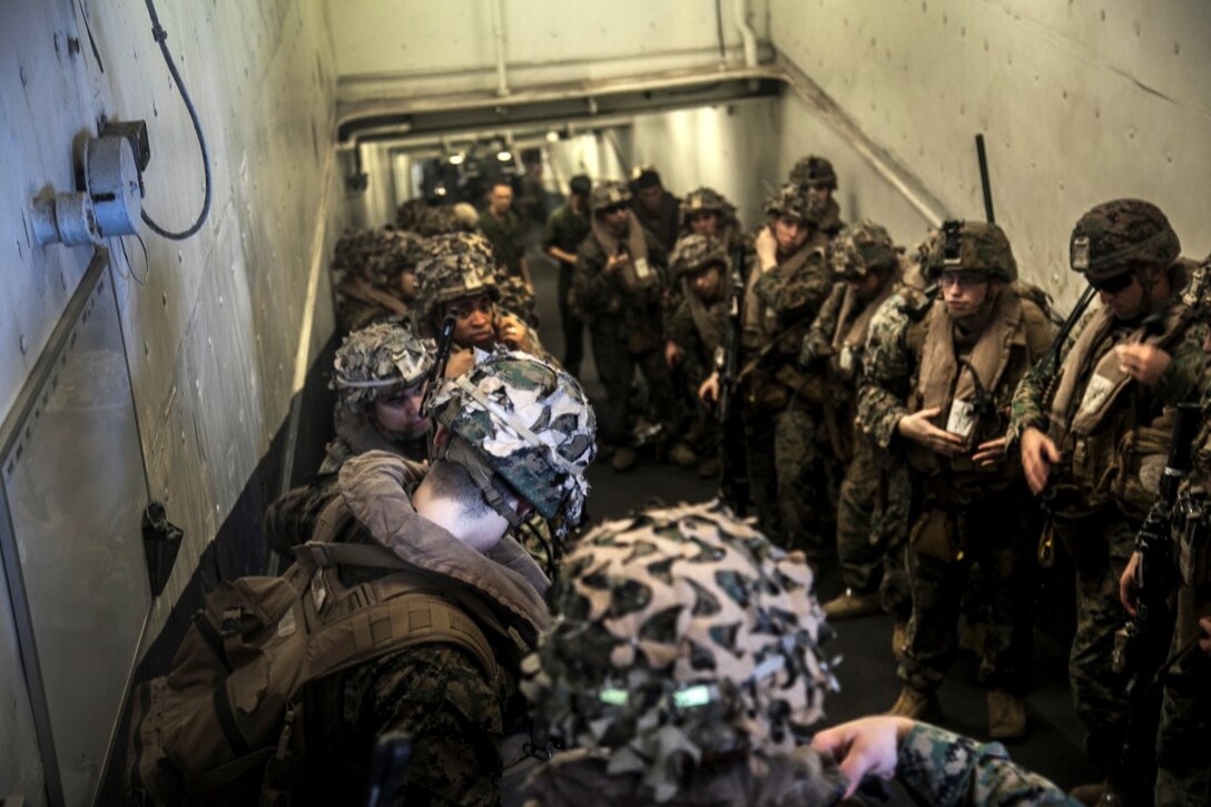 SOUTH CHINA SEA (Nov. 14, 2015) U.S. Marines with Lima Company, Battalion Landing Team 3rd Battalion, 1st Marine Regiment, 15th Marine Expeditionary Unit, prepare to board an aircraft during a quick reaction force rehearsal aboard the USS Essex (LHD 2). The 15th MEU is currently deployed in the Indo-Asia-Pacific region to promote regional stability and security in the U.S. 7th Fleet area of operations. (U.S. Marine Corps photo by Cpl. Elize McKelvey/Released)