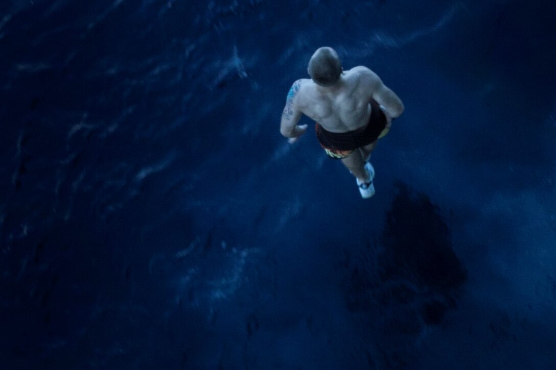 SOUTH CHINA SEA (Nov. 15, 2015) A U.S. Marine with the 15th Marine Expeditionary Unit  braces to hit the water after jumping off the side of the USS Essex (LHD 2) during a swim call. The Marines and Sailors of the 15th MEU and Essex Amphibious Ready Group jumped 30-feet into the water and swam to their respective check point. The 15th MEU is currently deployed in the Indo-Asia-Pacific region to promote regional stability and security in the U.S. 7th Fleet area of operations. (U.S. Marine Corps photo by Cpl. Elize McKelvey/Released)