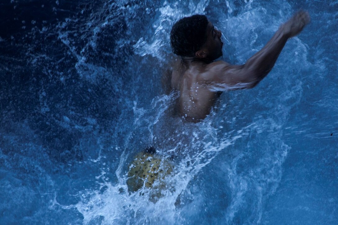 SOUTH CHINA SEA (Nov. 15, 2015) A U.S. Marine with the 15th Marine Expeditionary Unit  swims back to the USS Essex (LHD 2) after jumping off the side of the ship during a swim call. The Marines and Sailors of the 15th MEU and Essex Amphibious Ready Group jumped 30-feet into the water and swam to their respective check point. The 15th MEU is currently deployed in the Indo-Asia-Pacific region to promote regional stability and security in the U.S. 7th Fleet area of operations. (U.S. Marine Corps photo by Cpl. Elize McKelvey/Released)