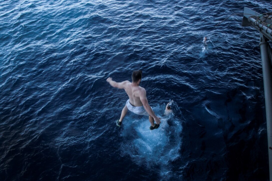 SOUTH CHINA SEA (Nov. 15, 2015)  U.S. Marines and Sailors with the 15th Marine Expeditionary Unit and Essex Amphibious Ready Group leap off the side of the USS Essex (LHD 2) during a swim call. The Marines and Sailors of the 15th MEU and Essex Amphibious Ready Group jumped 30-feet into the water and swam to their respective check point.  The 15th MEU is currently deployed in the Indo-Asia-Pacific region to promote regional stability and security in the U.S. 7th Fleet area of operations. (U.S. Marine Corps photo by Cpl. Elize McKelvey/Released)