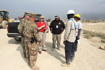 Karen R. Moore, project manager for the Environmental Footprint Reduction Program Afghanistan Program, discusses a sustainability project at Bagram Airfield Oct. 18 with Huntsville Center Commander Col. Robert Ruch and Deputy Commander Lt. Col. Burlin Emery, and contractors Acery Garcia, Sterling Global EFR regional manager; Fredrick Ouma, team lead, and Elmer Rivera, military heavy equipment operator.