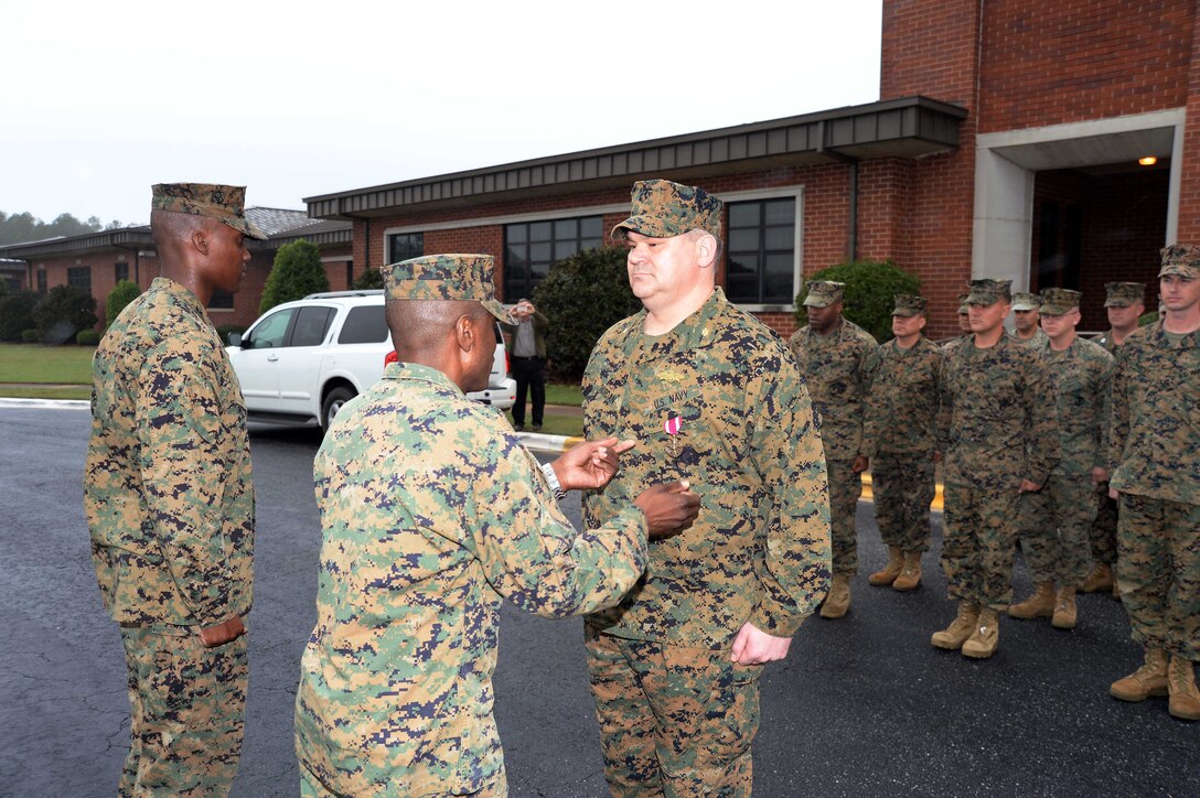 Standing at attention in front of a formation of fellow service members and civilian-Marines at Marine Corps Logistics Base Albany, Lt. Cmdr. Dennis J. Riordan, receives a commendation during a brief ceremony honoring his achievement. Col. James C. Carroll III, commanding officer, MCLB Albany, pinned the Meritorious Service Medal on Riordan, public works officer, Installation and Environmental Branch, MCLB Albany, while Lt. Col. Nathaniel Robinson, executive officer, MCLB Albany, read President Barack Obama’s citation. The event was held at Coffman Hall, Bldg. 3500, Nov. 9.