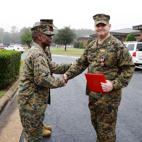 Standing at attention in front of a formation of fellow service members and civilian-Marines at Marine Corps Logistics Base Albany, Lt. Cmdr. Dennis J. Riordan, receives a commendation during a brief ceremony honoring his achievement. Col. James C. Carroll III, commanding officer, MCLB Albany, pinned the Meritorious Service Medal on Riordan, public works officer, Installation and Environmental Branch, MCLB Albany, while Lt. Col. Nathaniel Robinson, executive officer, MCLB Albany, read President Barack Obama’s citation. The event was held at Coffman Hall, Bldg. 3500, Nov. 9.