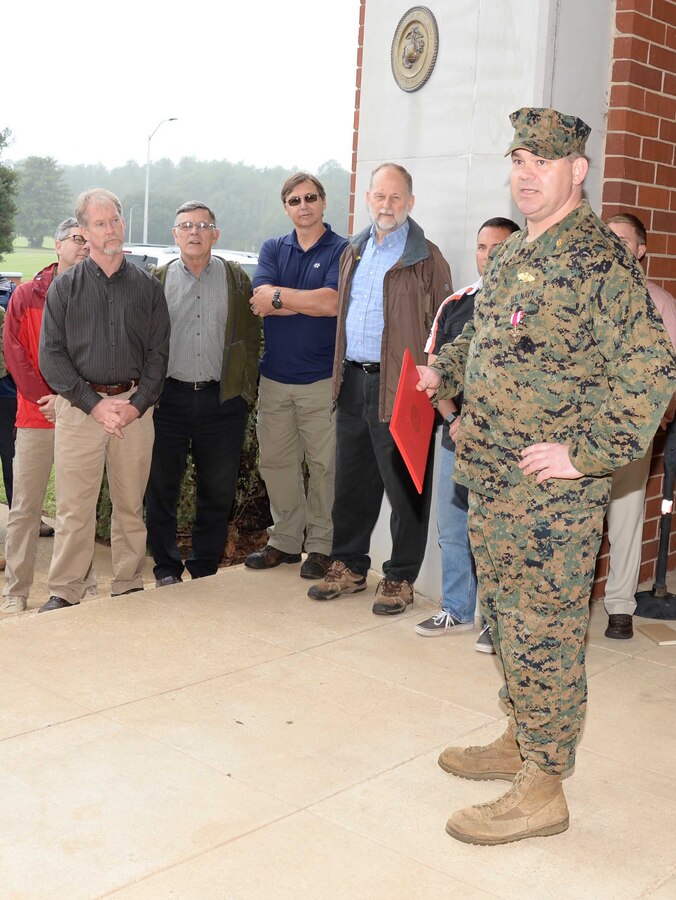 Standing at attention in front of a formation of fellow service members and civilian-Marines at Marine Corps Logistics Base Albany, Lt. Cmdr. Dennis J. Riordan, receives a commendation during a brief ceremony honoring his achievement. Col. James C. Carroll III, commanding officer, MCLB Albany, pinned the Meritorious Service Medal on Riordan, public works officer, Installation and Environmental Branch, MCLB Albany, while Lt. Col. Nathaniel Robinson, executive officer, MCLB Albany, read President Barack Obama’s citation. The event was held at Coffman Hall, Bldg. 3500, Nov. 9.