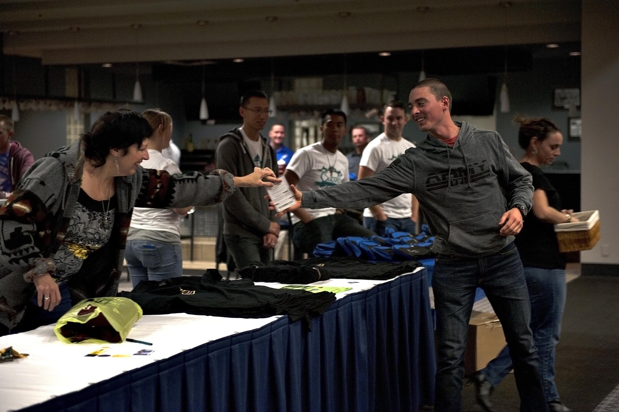 Laurel L. Matus, 17th Training Wing Sexual Assault Prevention and Response victim advocate, hands out an award to a participant during the 4th Annual SAPR Guys Night Out event at the Event Center on Goodfellow Air Force Base, Texas, Nov. 12, 2015. SAPR program officials held the event and gave out many prizes by drawing raffle tickets. (U.S. Air Force photo by Airman 1st Class Caelynn Ferguson/Released)